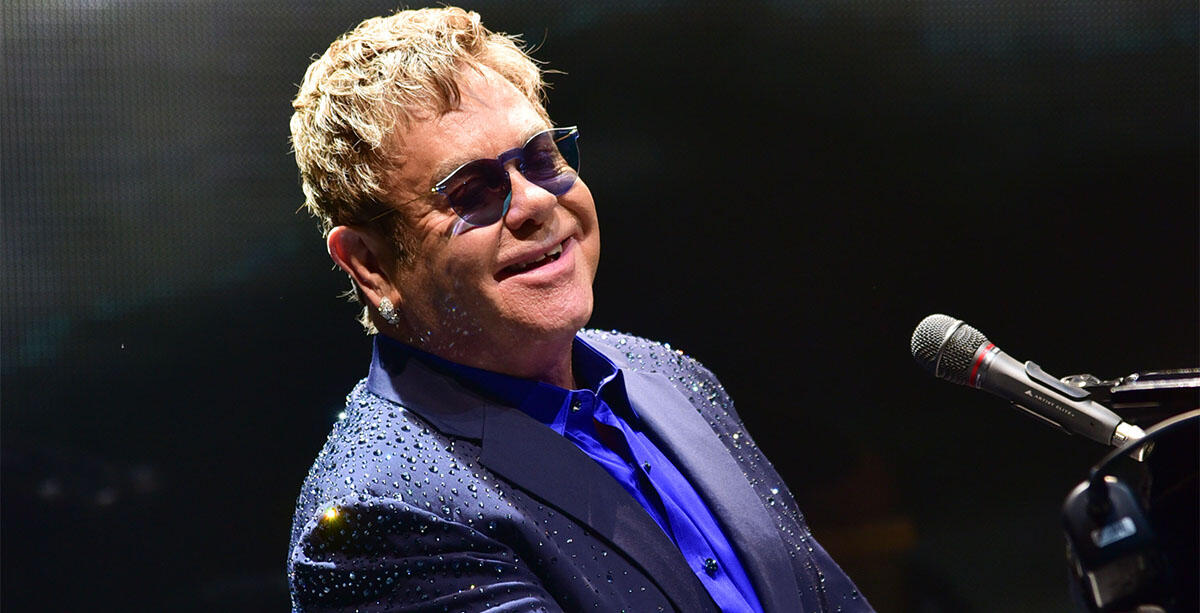 Elton John grający na pianinie podczas koncertu
