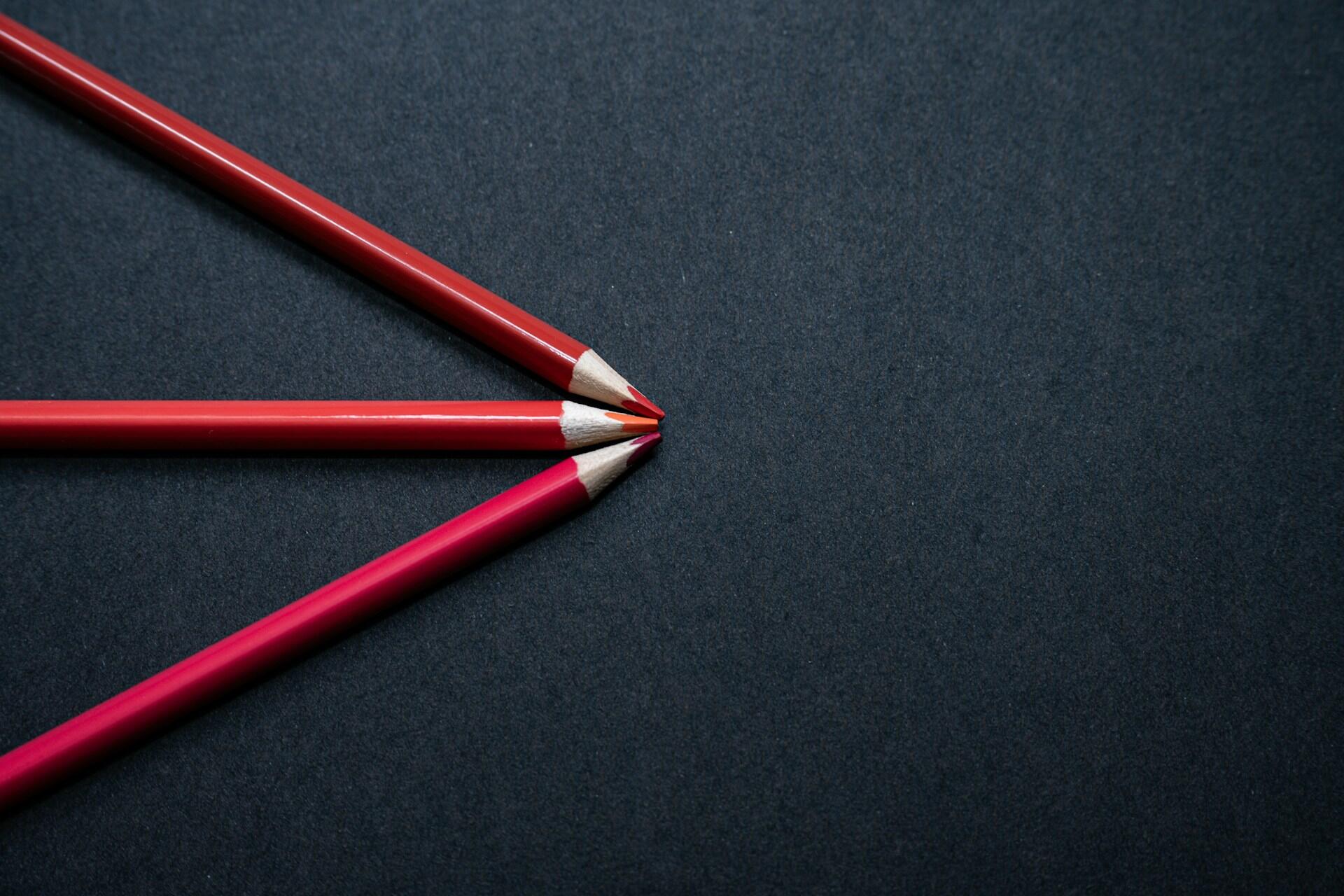 Czerwone kredki ułożone w trójkąt.