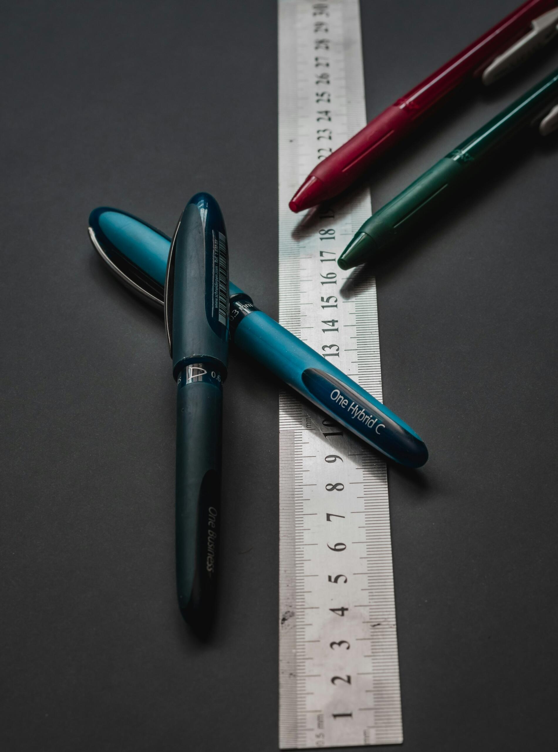 Kolorowe długopisy i centymetr.