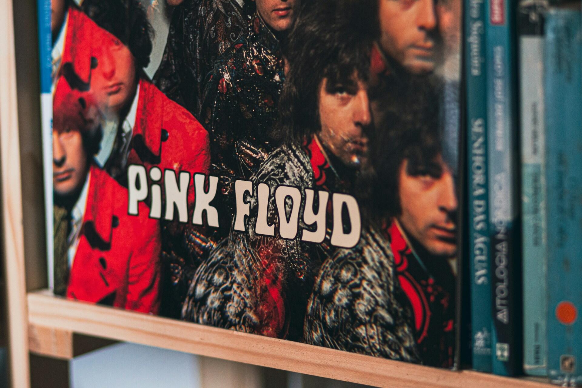 Okładka płyty Pink Floyd na drewnianej półce.