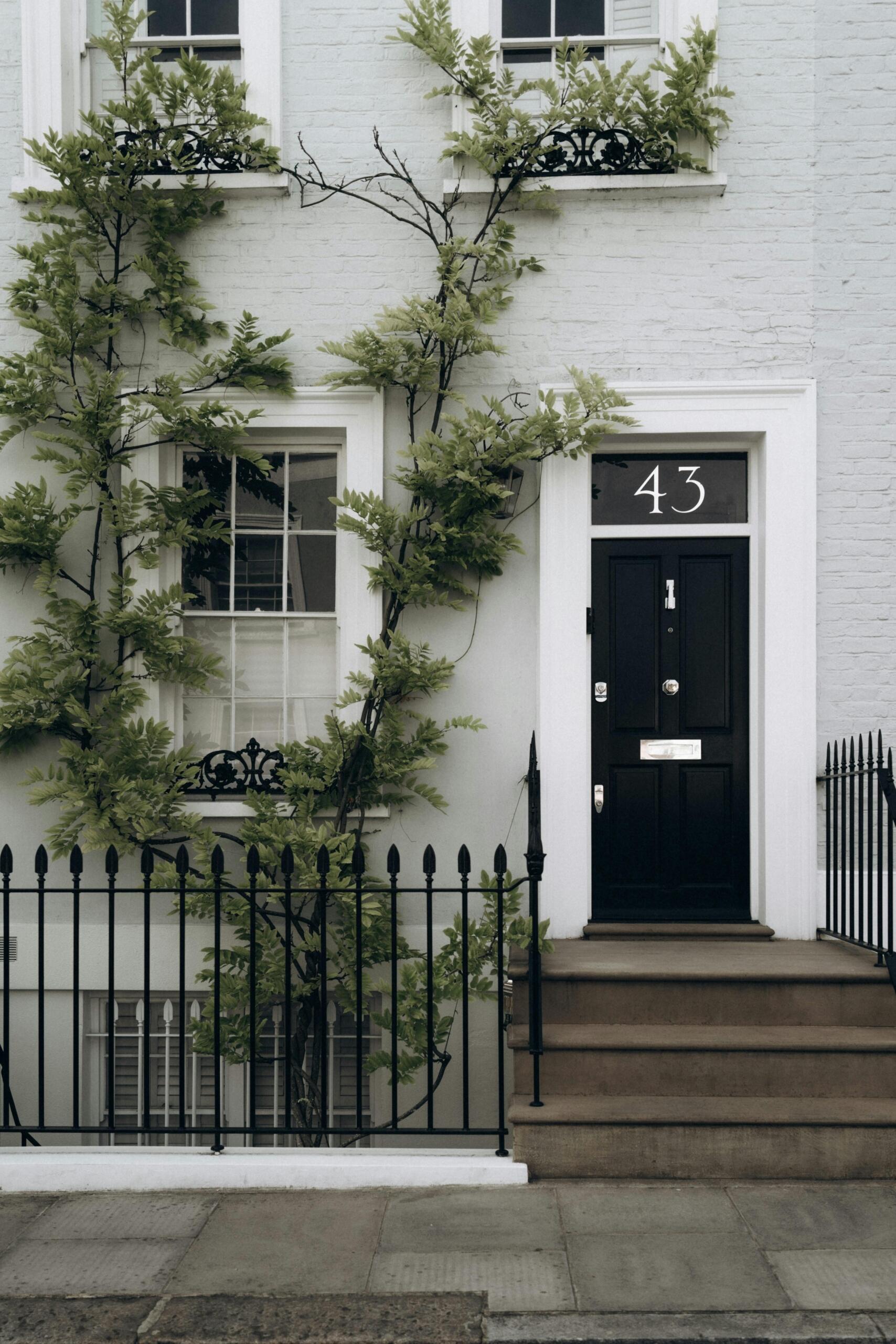 Widok na białą kamienicę z czarnymi drzwiami w Notting Hill w Londynie