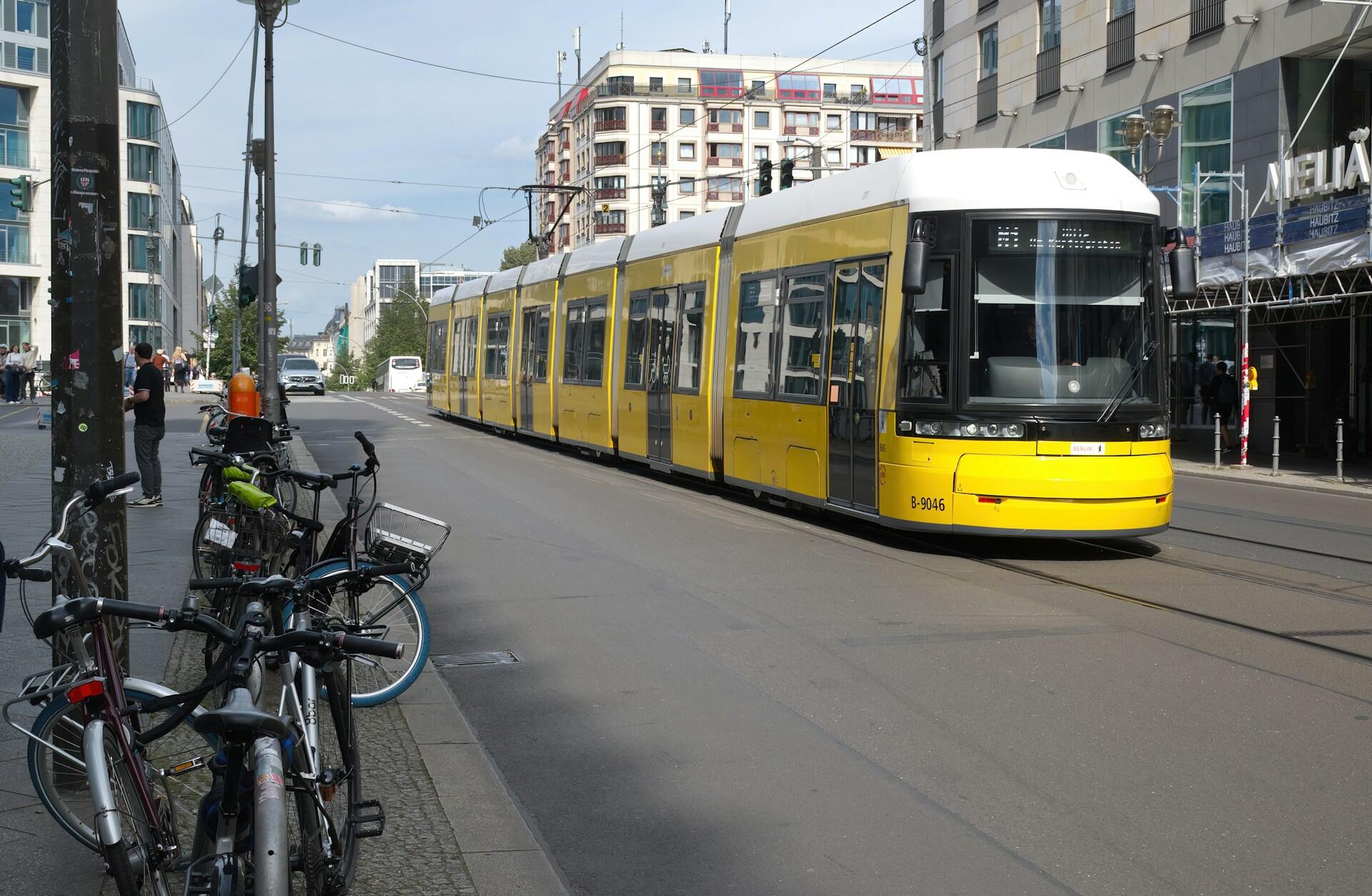 Żółty tramwaj i rowery na ulicy.