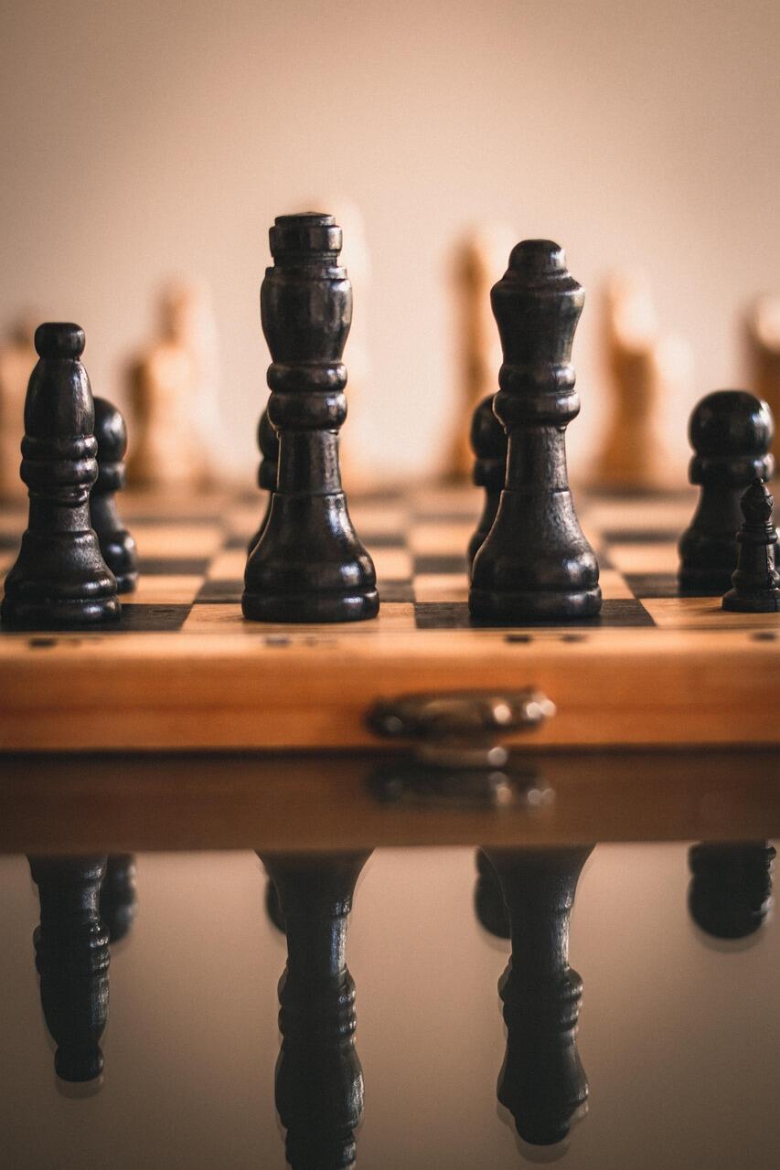 Szachownica z drewnianymi figurami i jej odbicie lustrzane