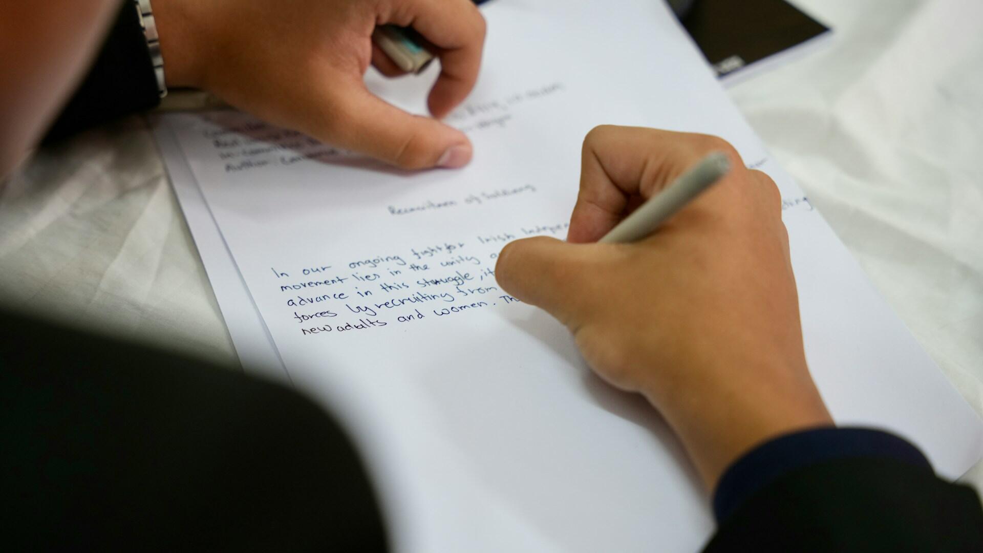 Uczeń pisze wypracowanie na egzaminie w szkole