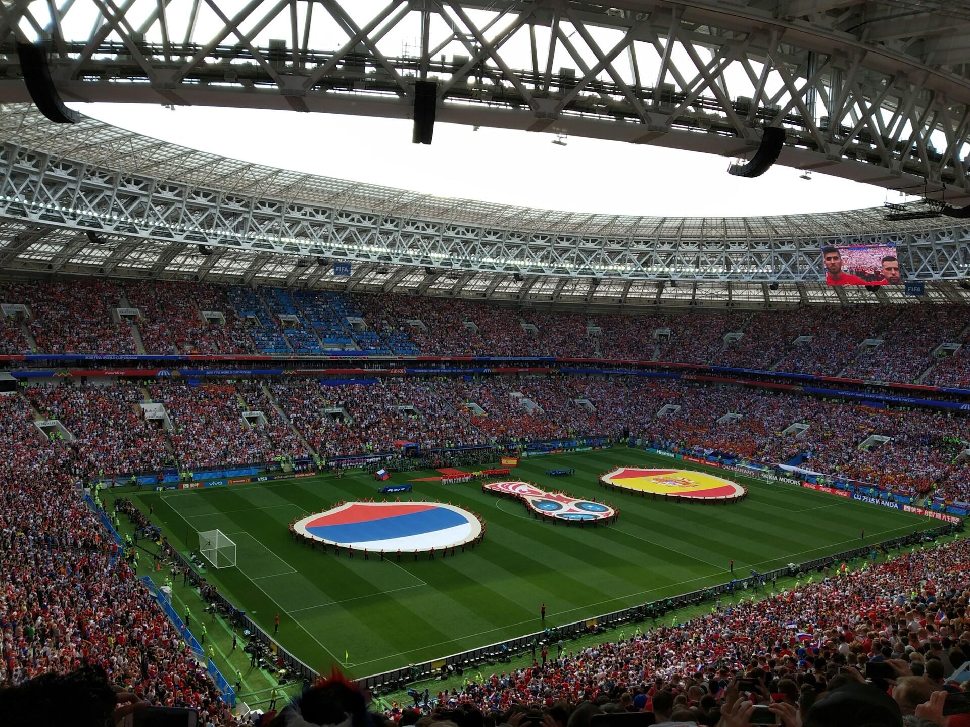 Przed meczem na boisku piłkarskim zgromadził się tłum kibiców, a na trybunach powiewały wielkie okrągłe flagi Rosji, FIFA i Hiszpanii.