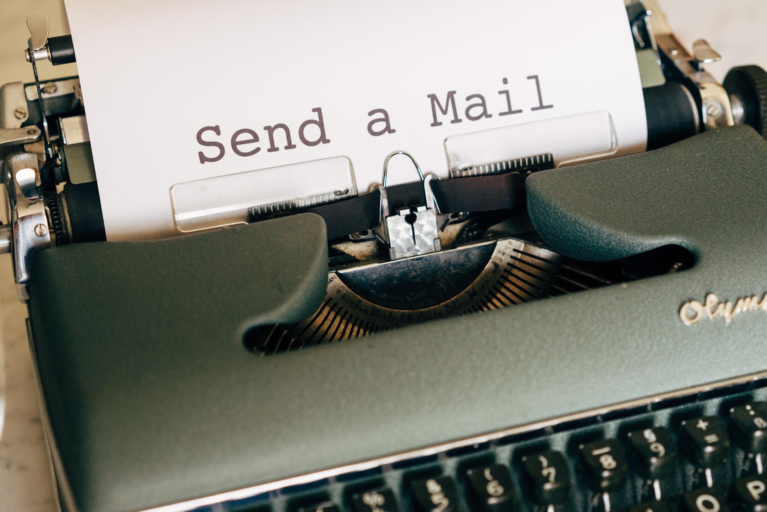 Maszyna do pisania, z której wysuwa się kartka z napisem "send a mail"