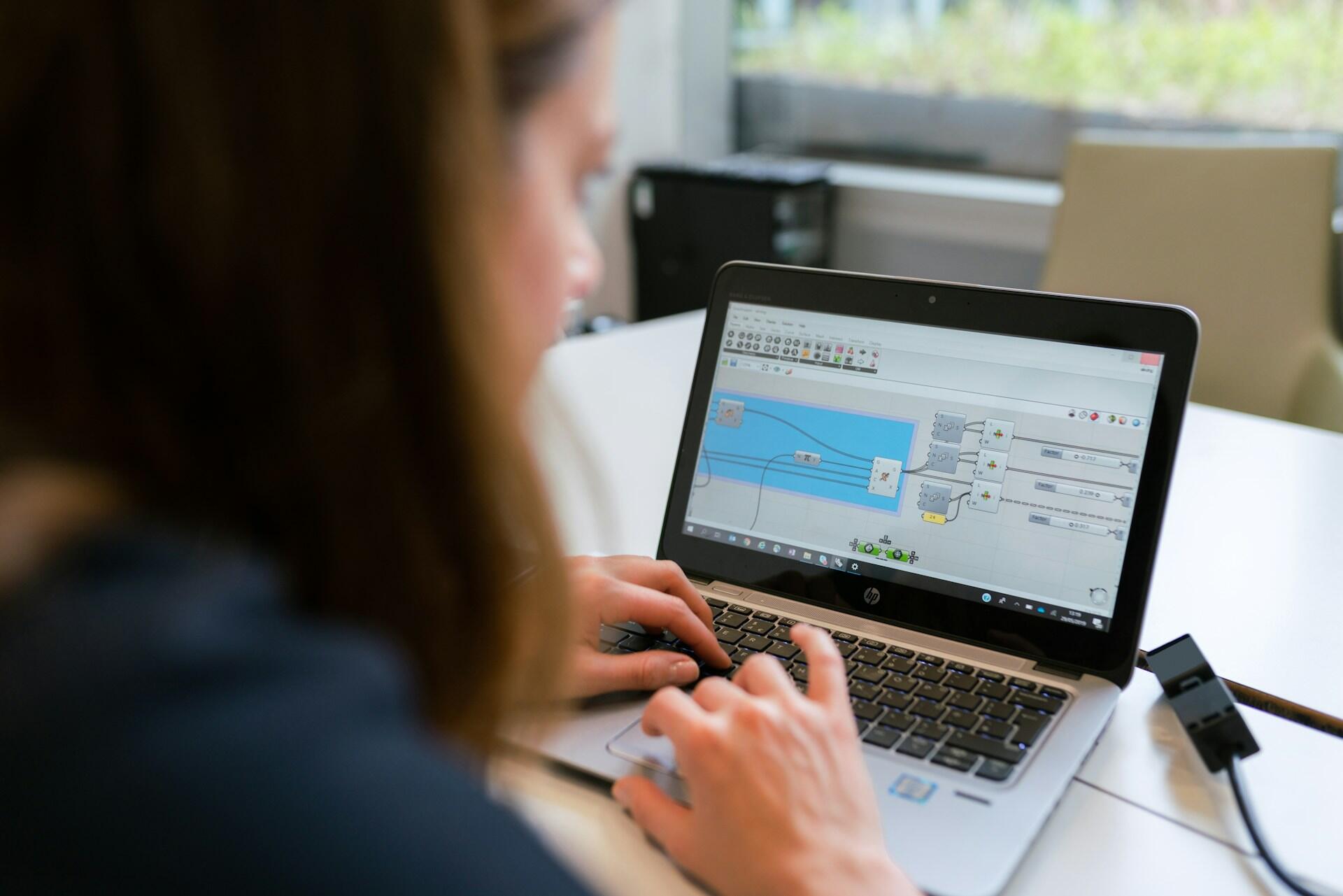 Kobieta inżynier elektryk pracuje na laptopie przy projekcie oświetlenia. Unsplash: ThisisEngineering