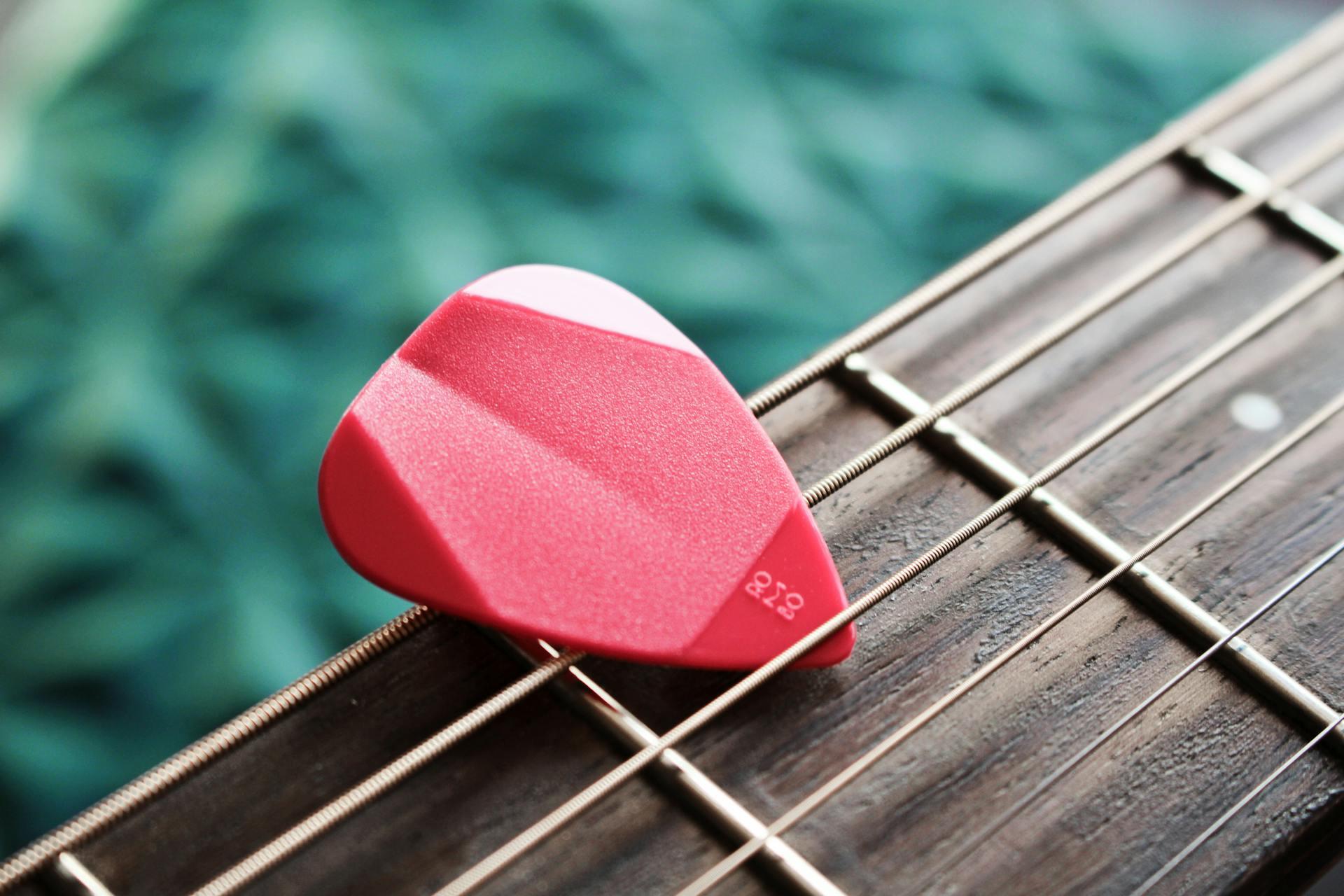 palheta vermelha em braço de guitarra