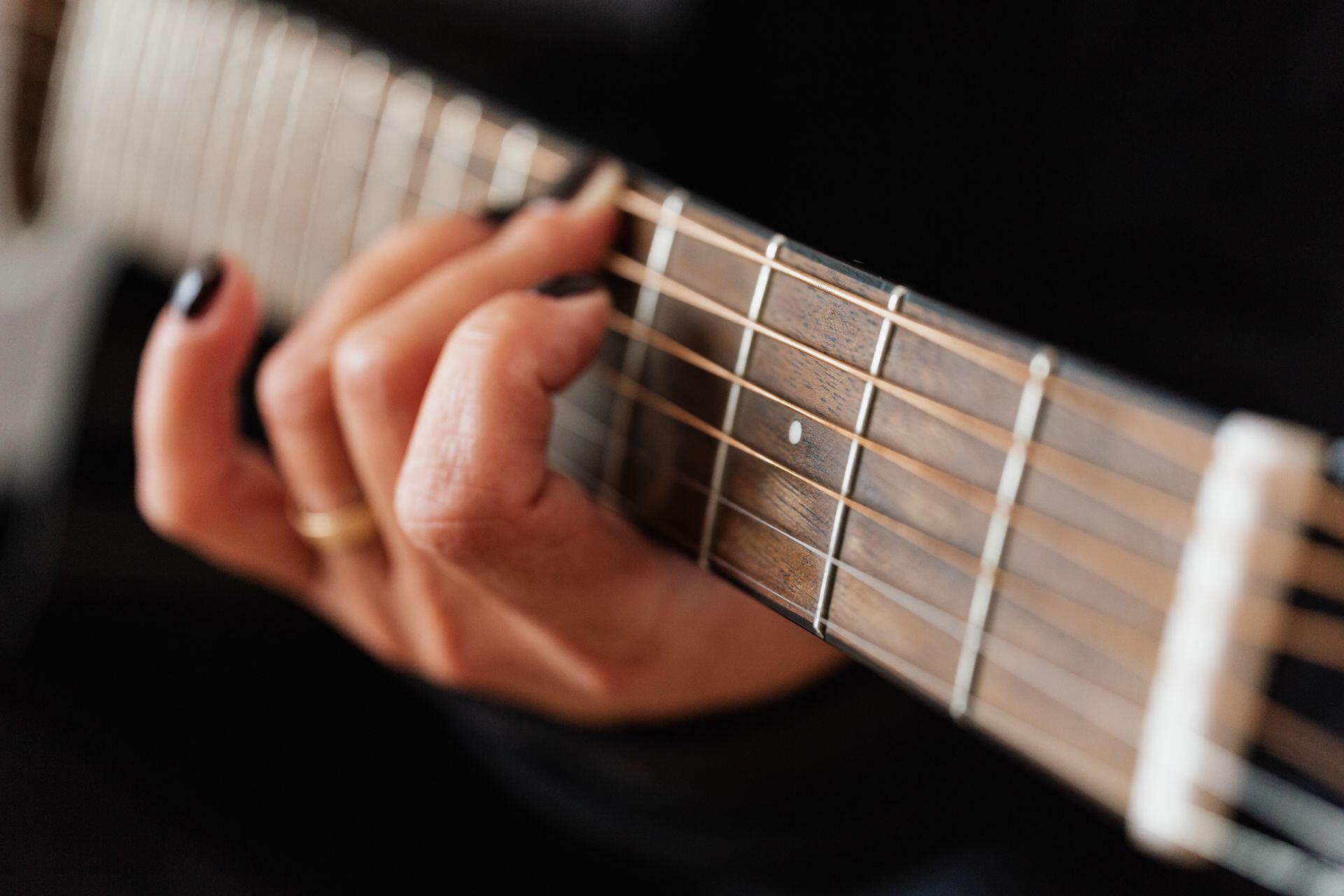 mão de mulher em cabo de guitarra