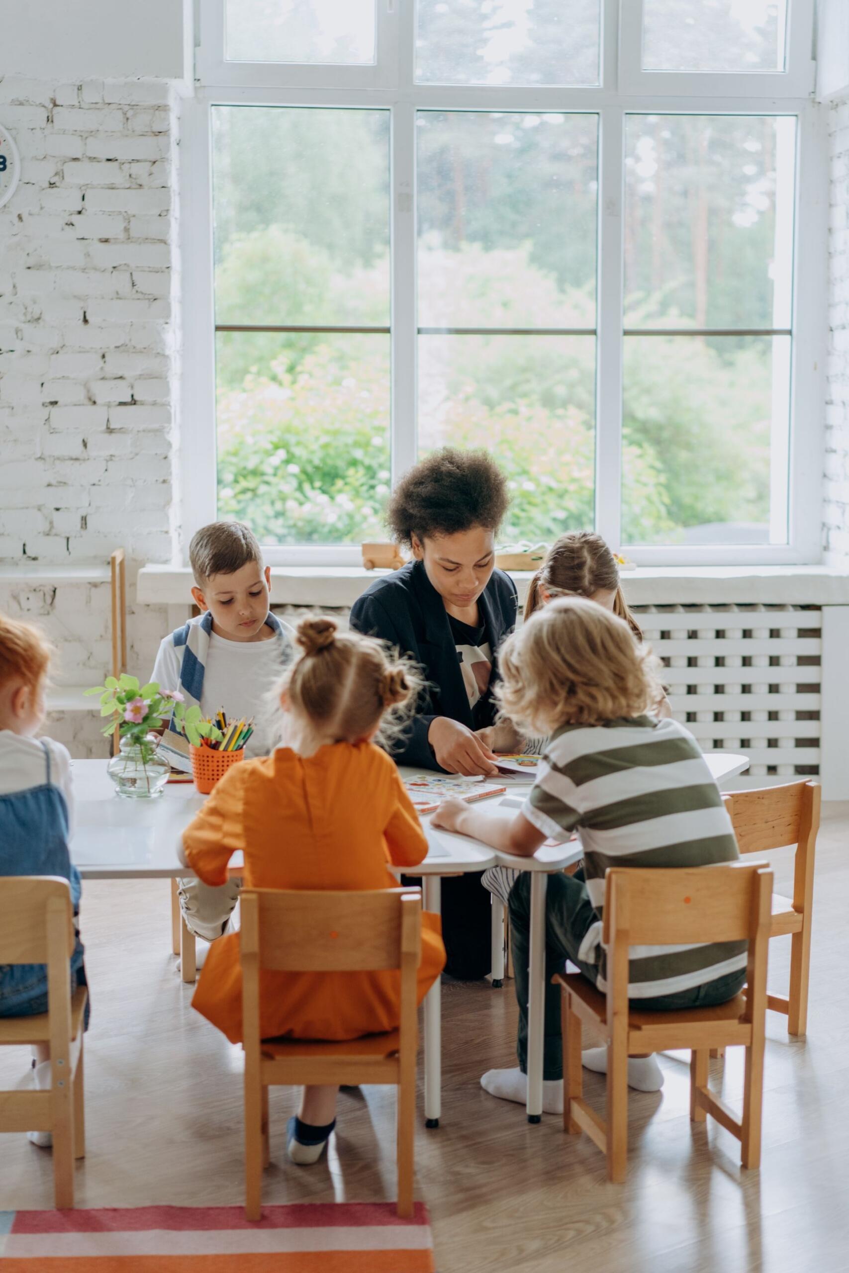 professora com vários alunos numa mesa