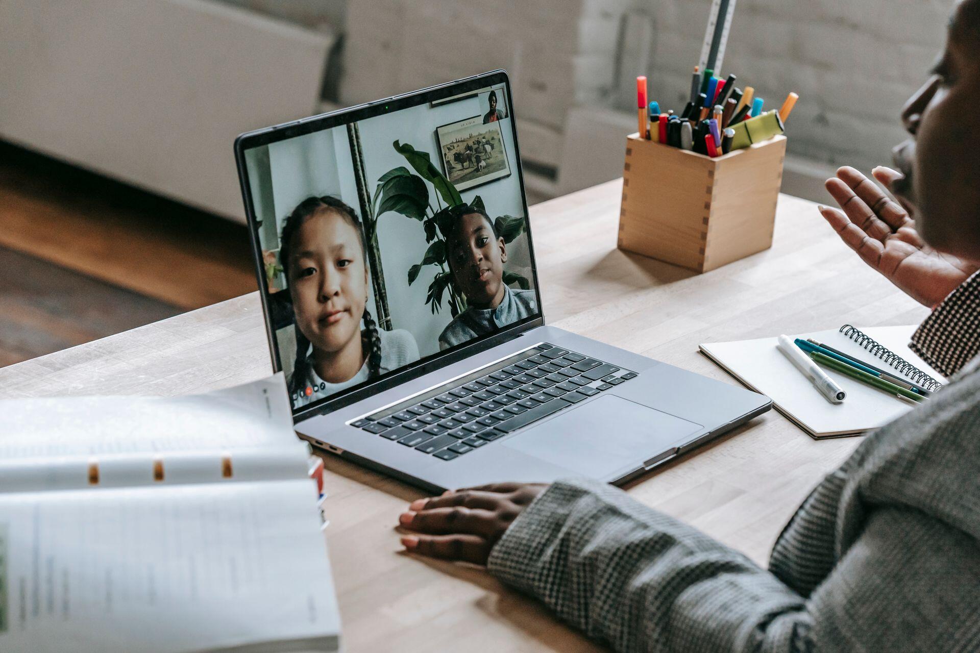 dois alunos em eaula online com professora
