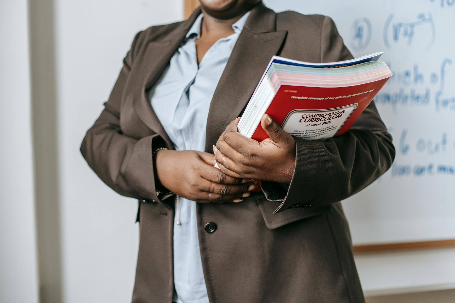 mulher com camisa e blazer a segurar em livros