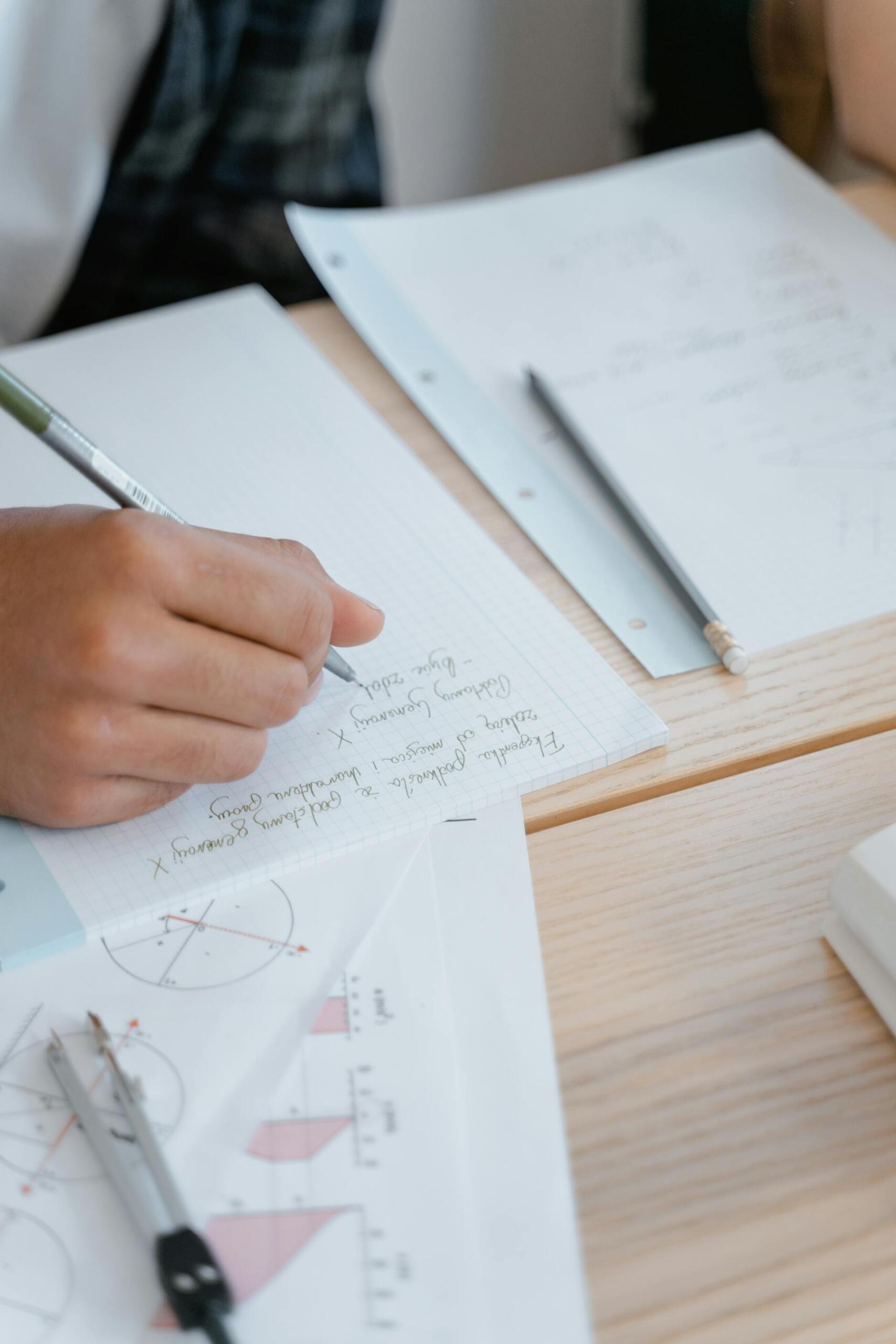mão de pessoa a resolver exercícios matemática