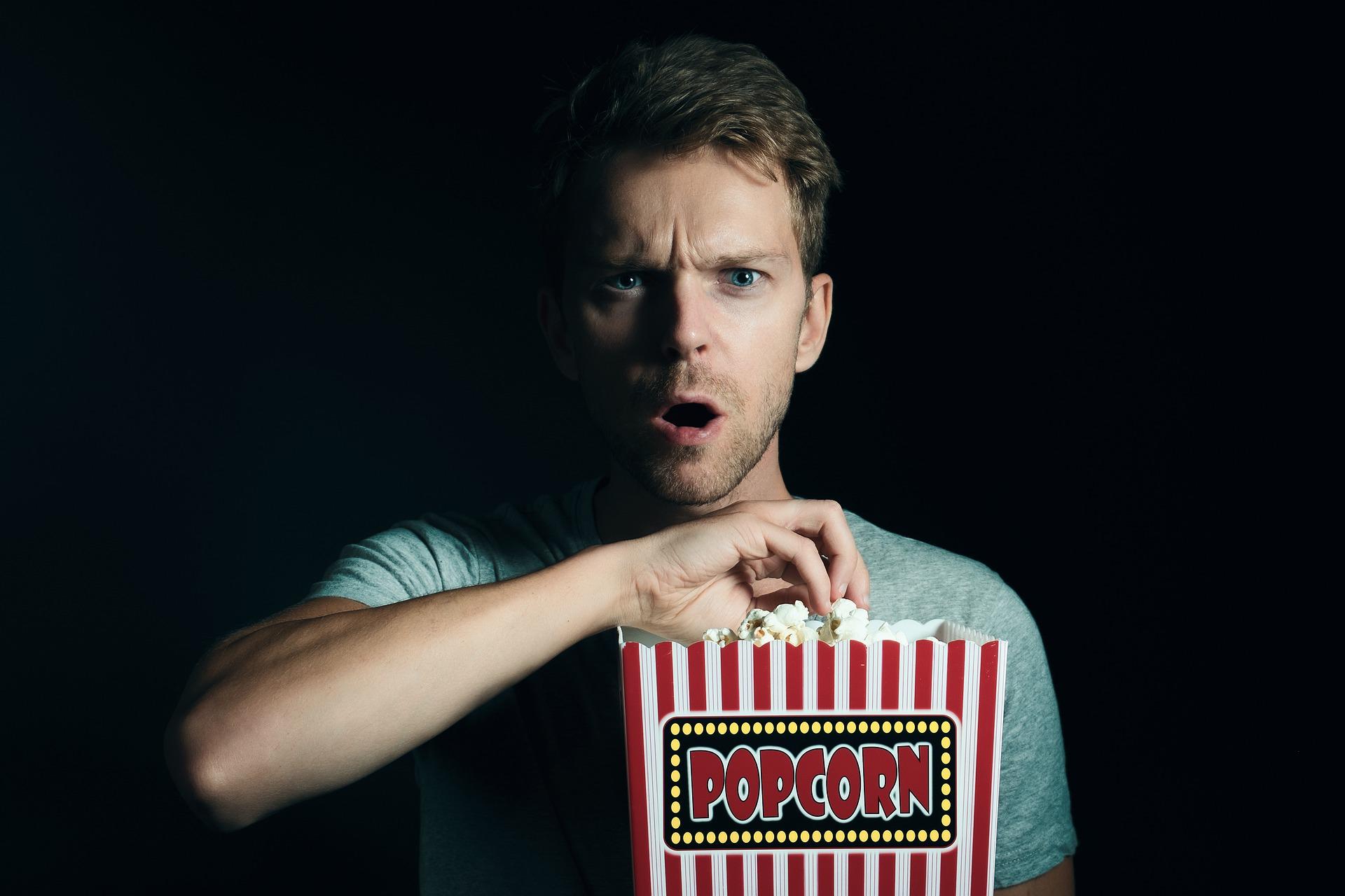 homem a comer pipocas de um balde