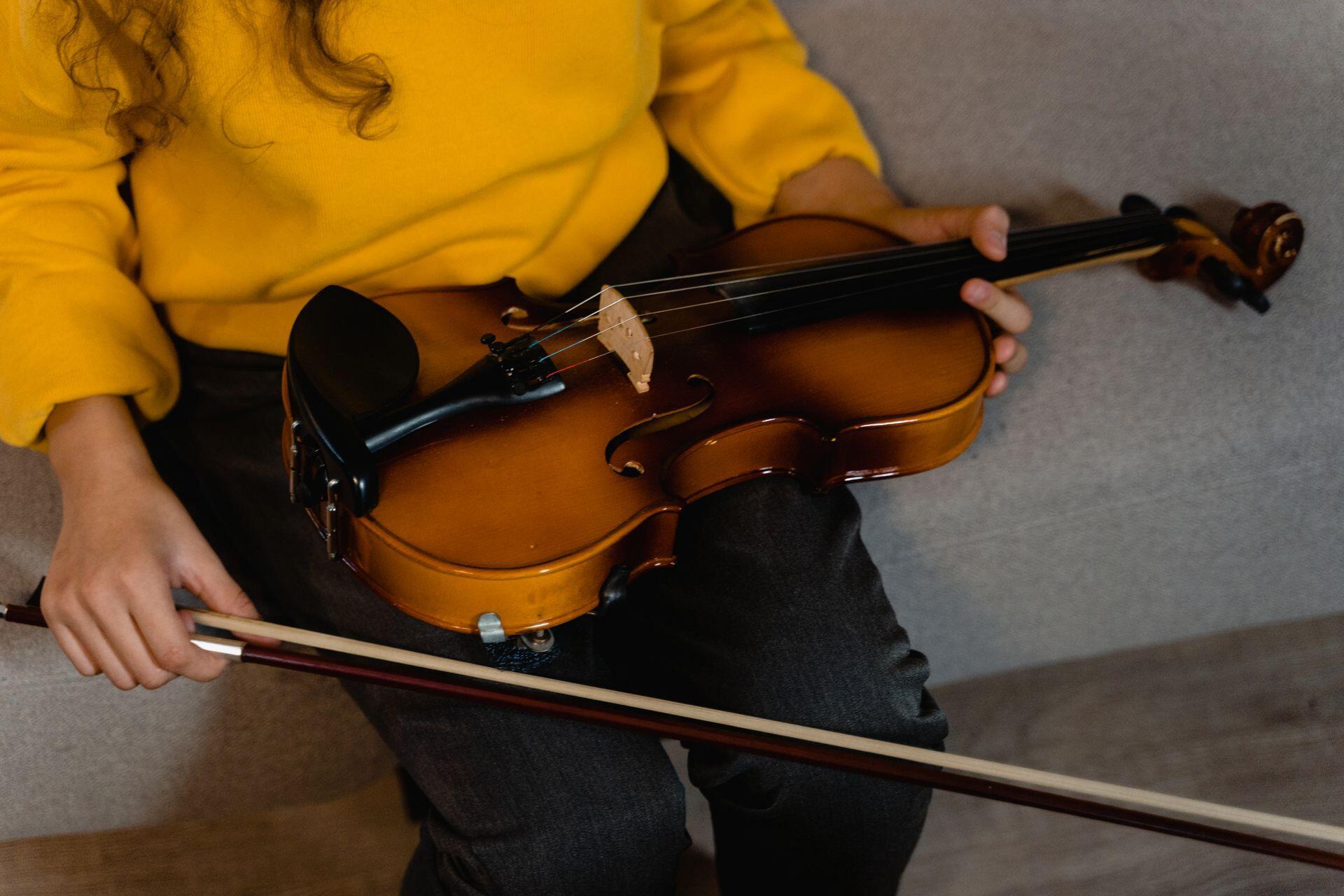 Pessoa a segurar violino no colo