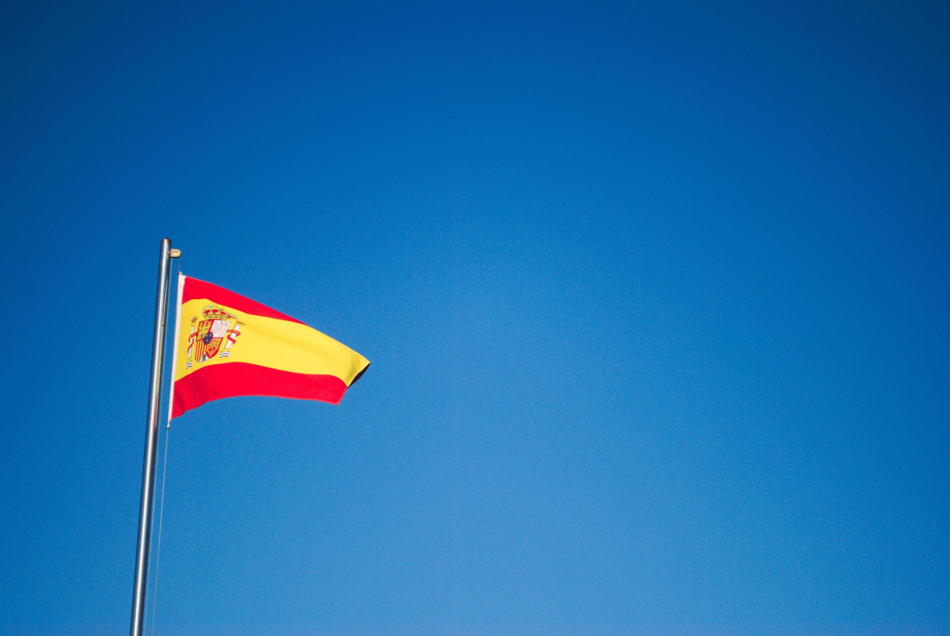 A bandeira de Espanha, o símbolo da língua e cultura espanhola, a esvoaçar ao vento.