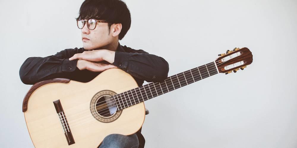 Professor de guitarra espera sentado pelos seus alunos