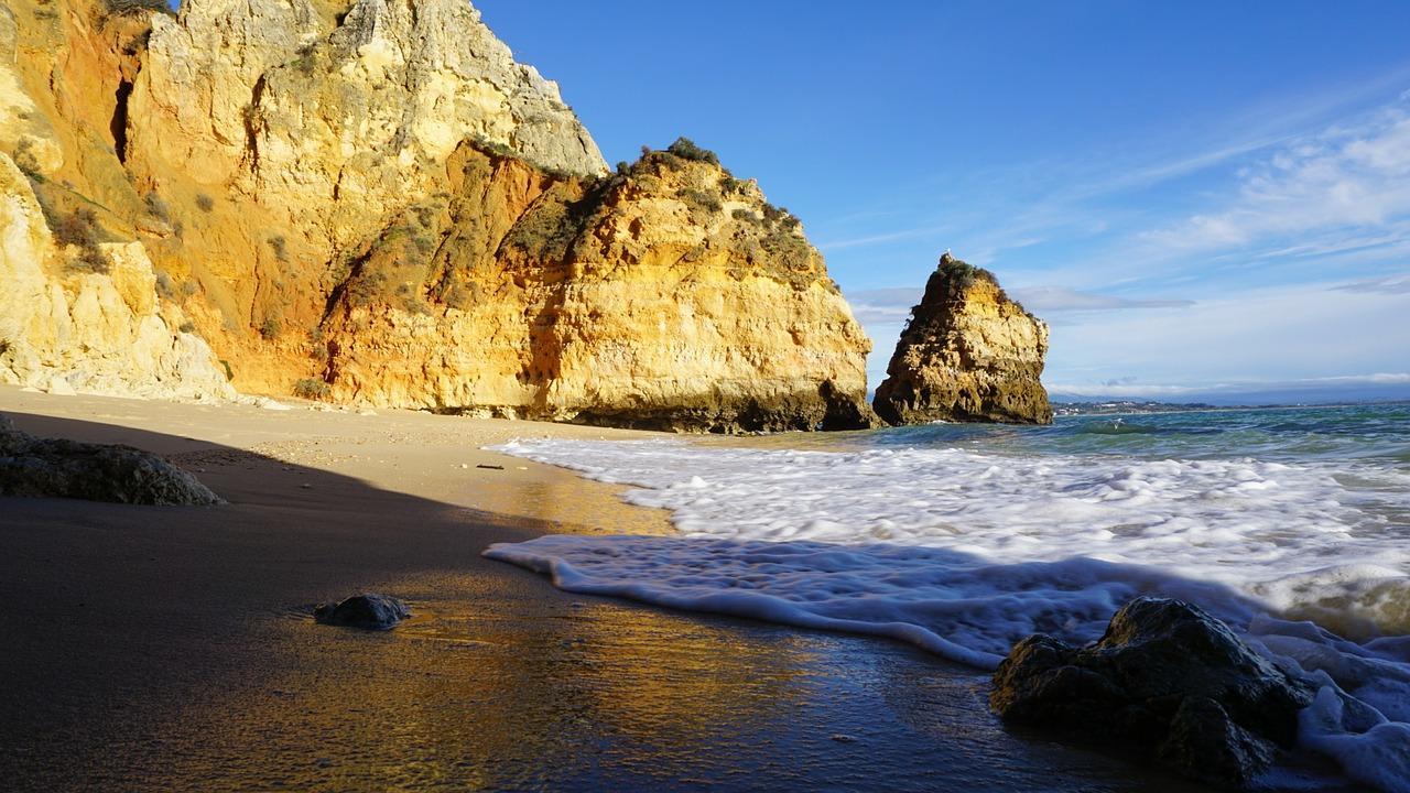 Fotografia da falésia, da praia e do mar tirada numa das praias de Faro.