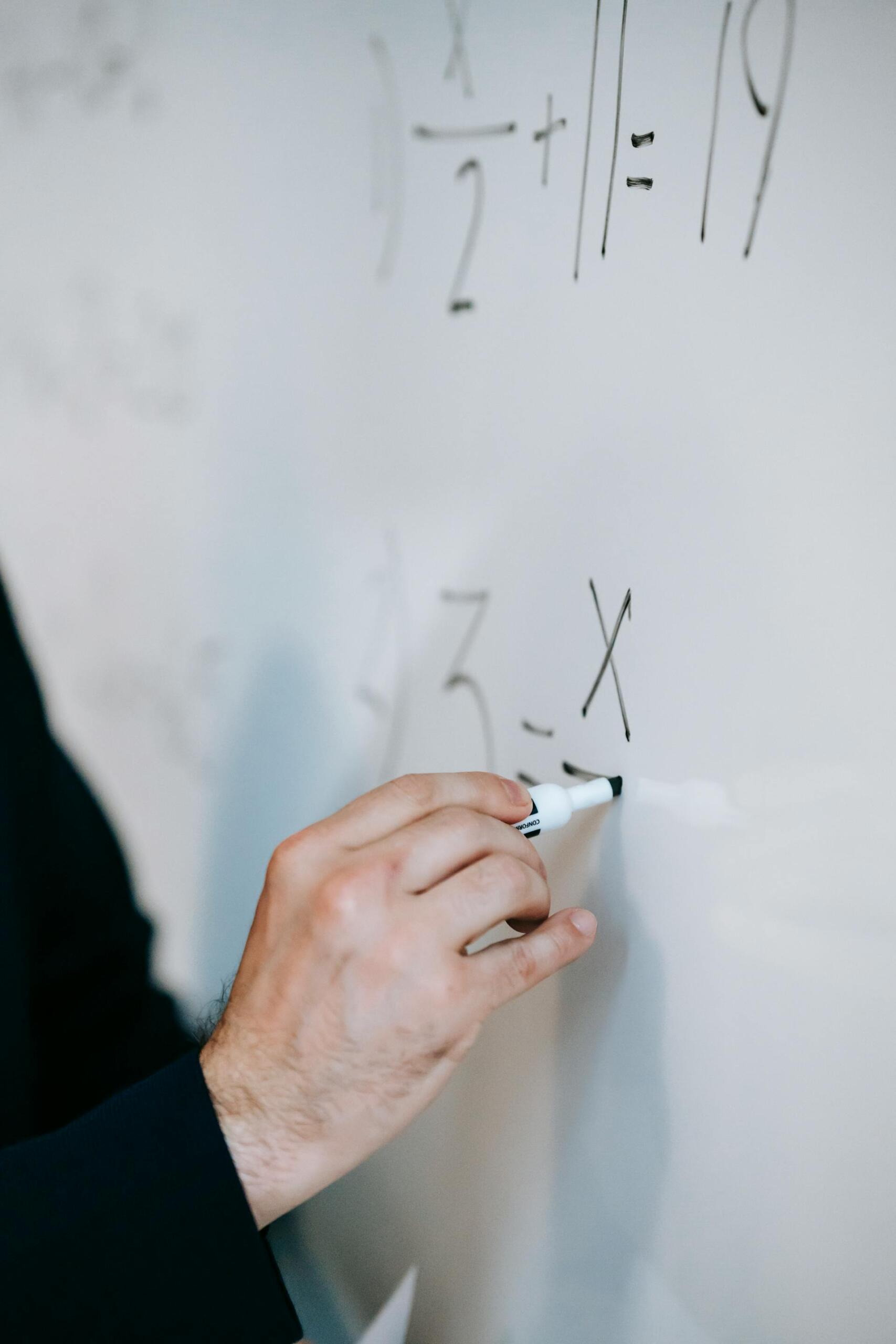 pessoa a escrever equação em quadro