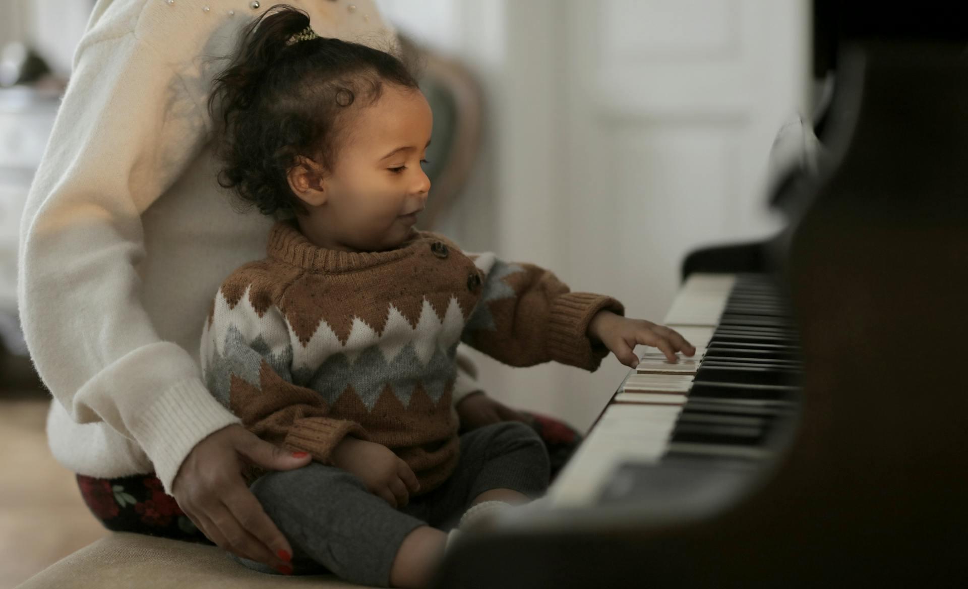 menina pequenina com a mãe em frente ao piano