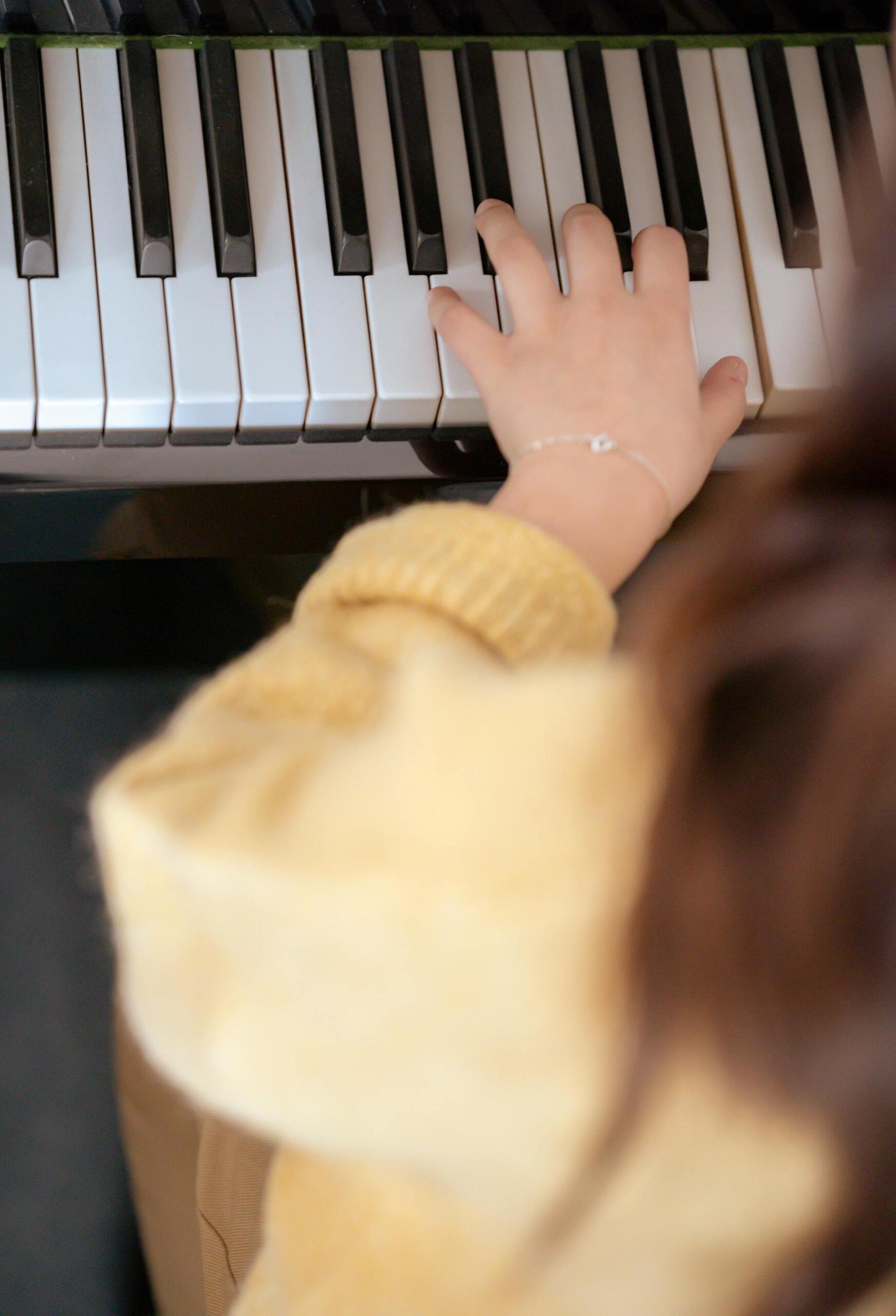 mão de criança em teclas de piano