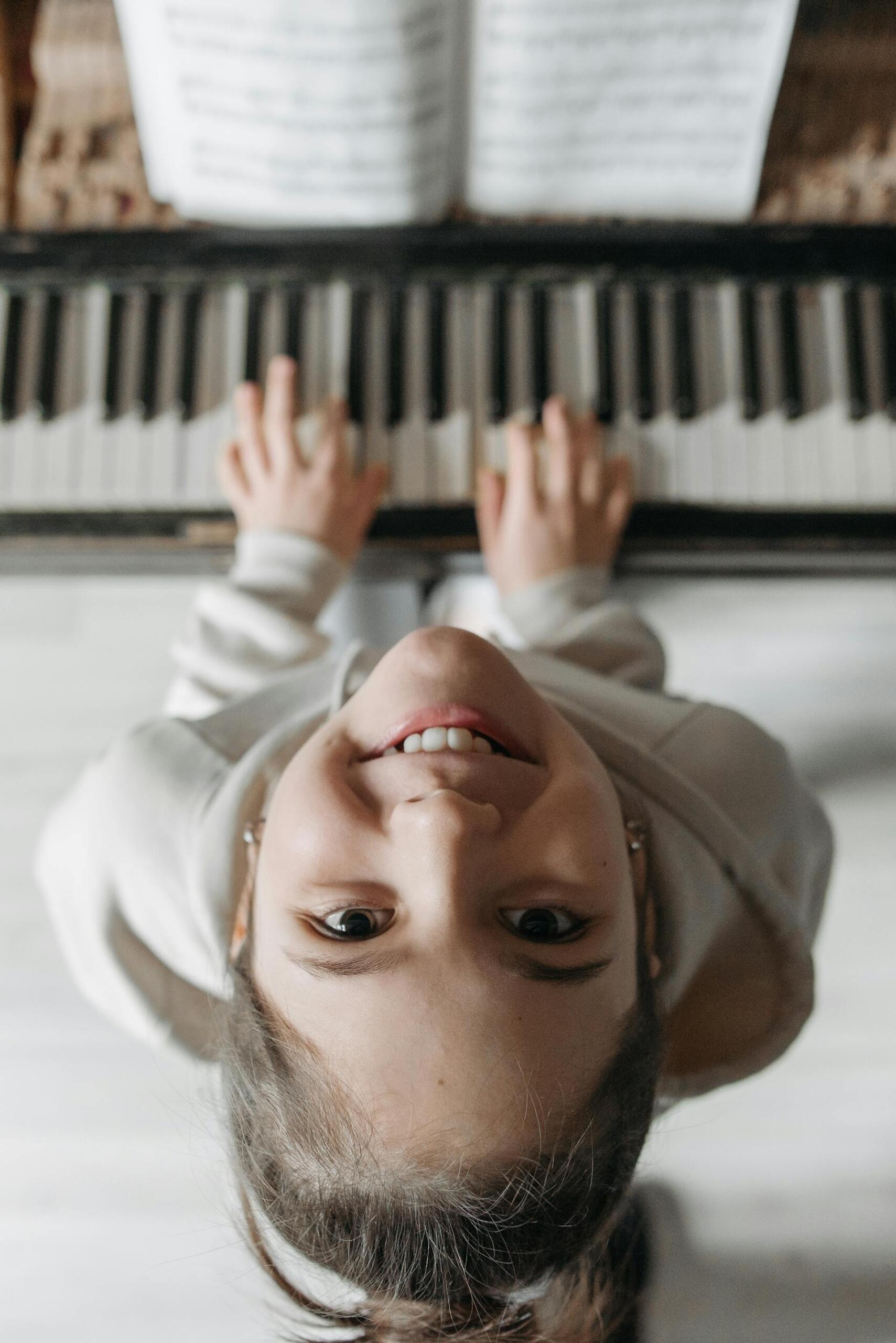 menina a sorrir a tocar no piano