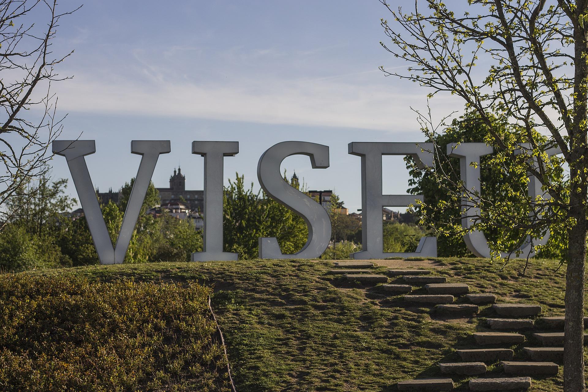 Uma estrutura da palavra Viseu com uma paisagem por trás