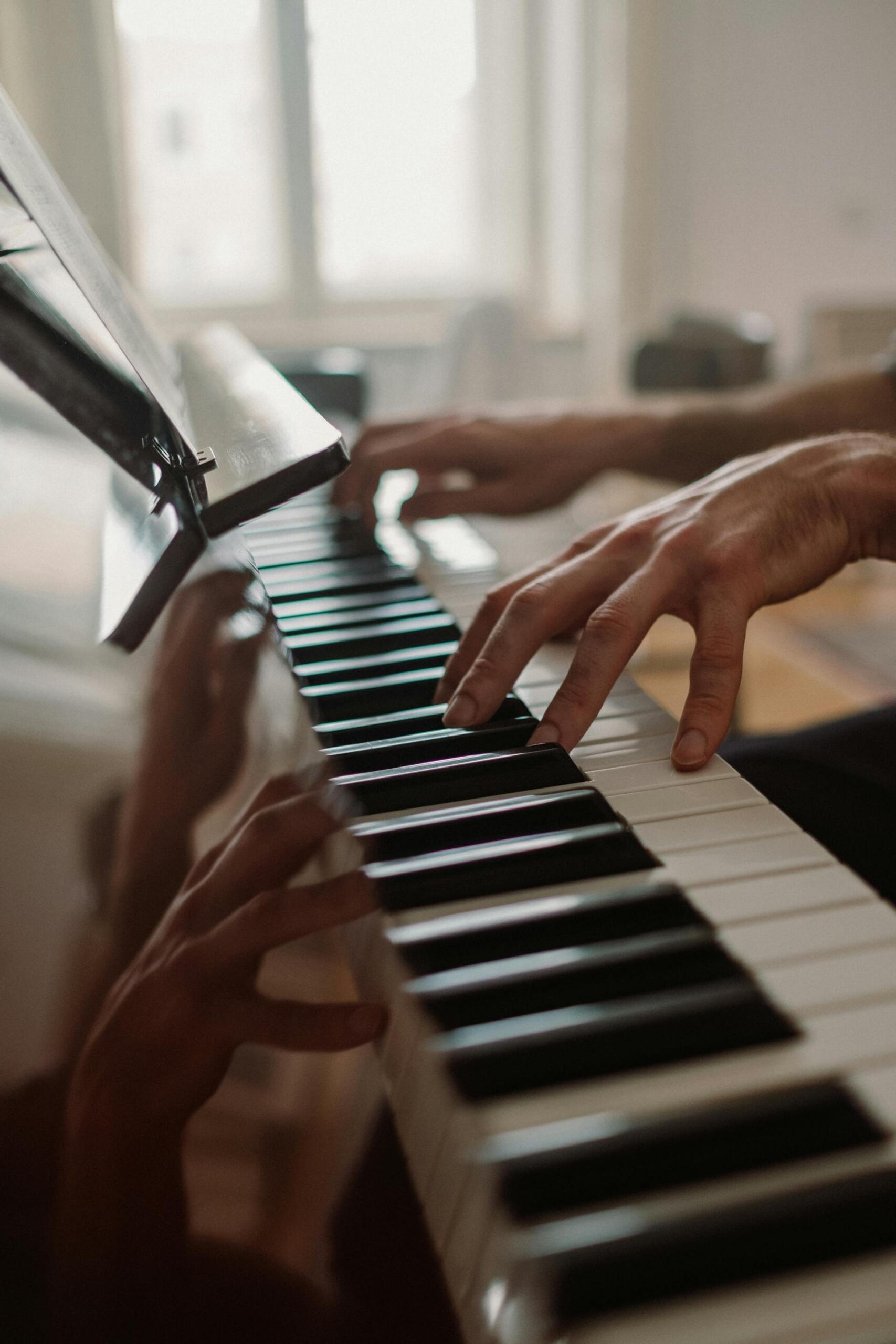 pessoa a tocar piano com as duas mãos