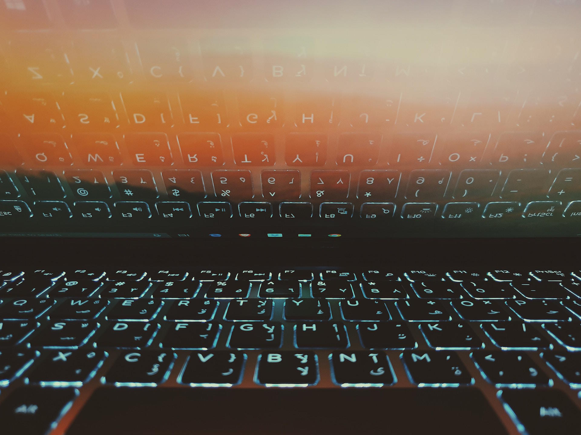 Teclado iluminado reflete em ecrã de computador