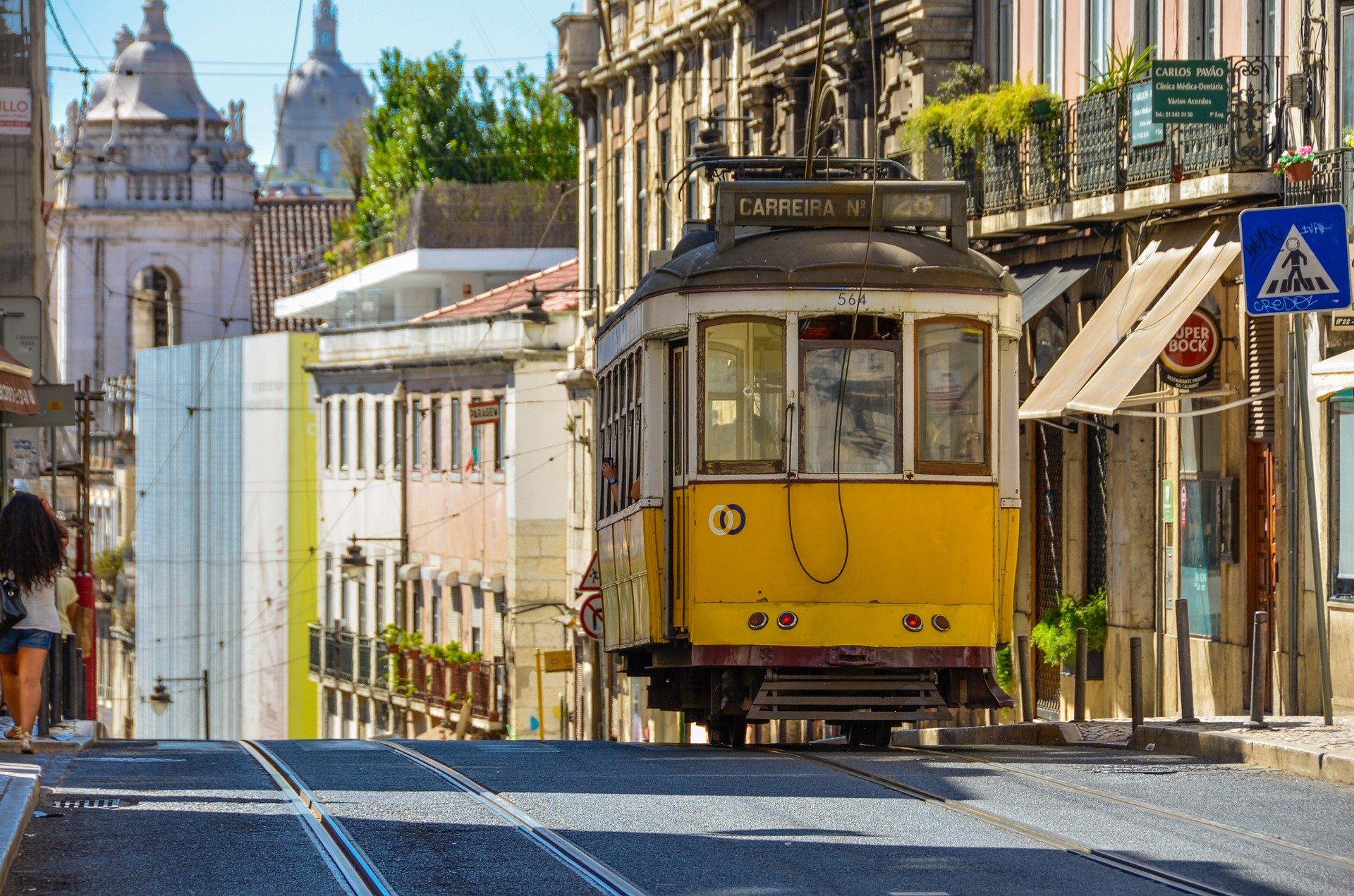 Uma fotografia do elétrico 28 a subir a rua, em Lisboa.