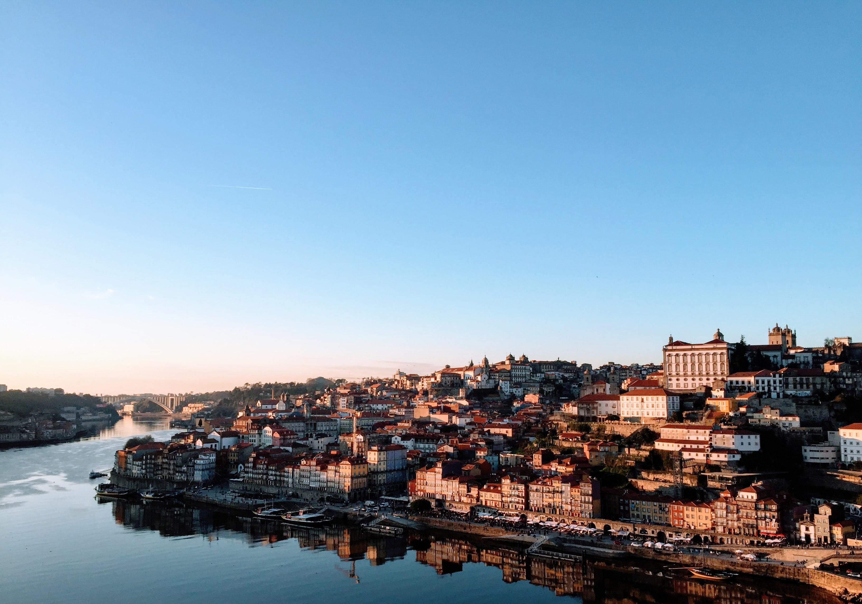 Uma fotografia da cidade do Porto, à beira rio.