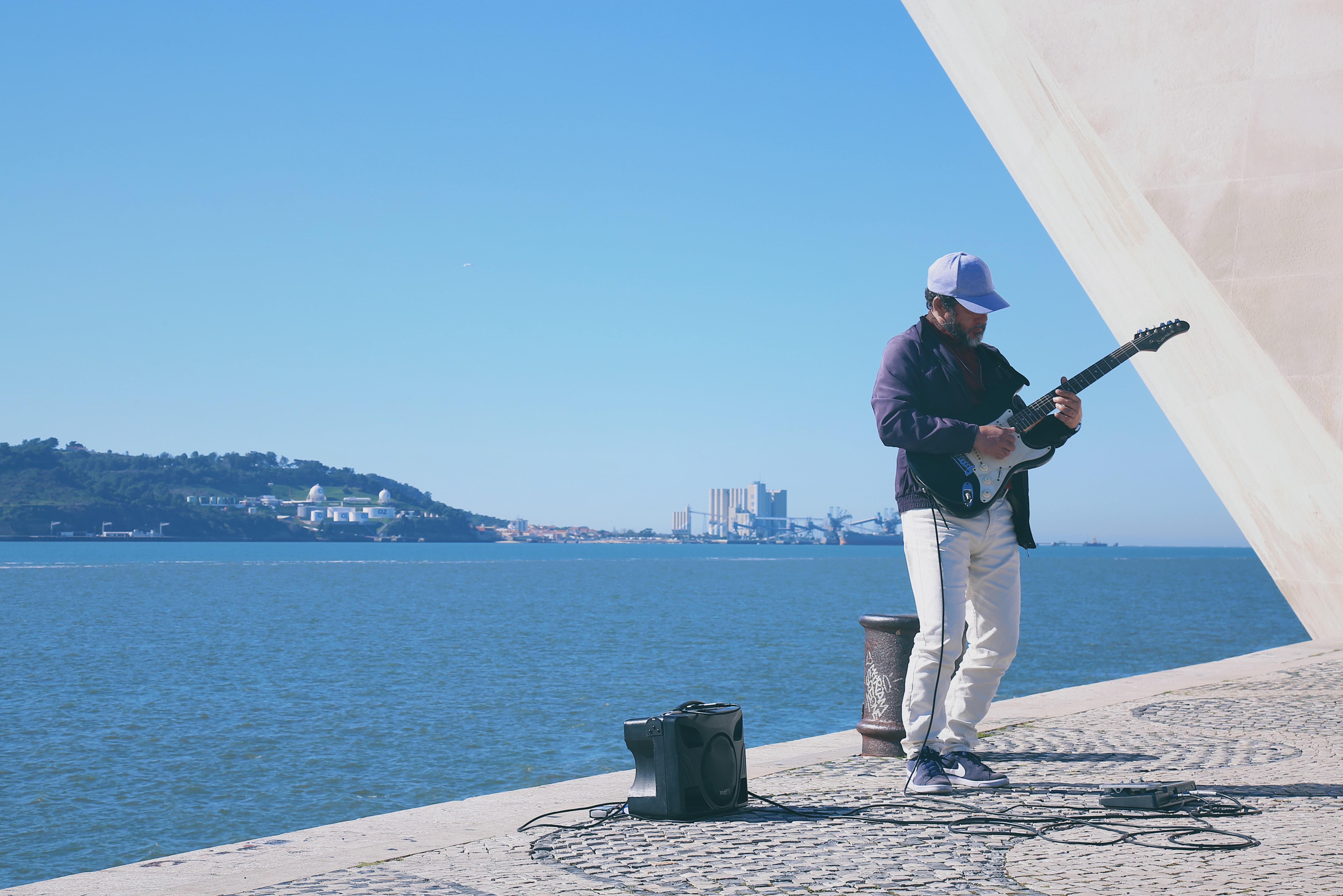 Guitarrista com o mar como cenário