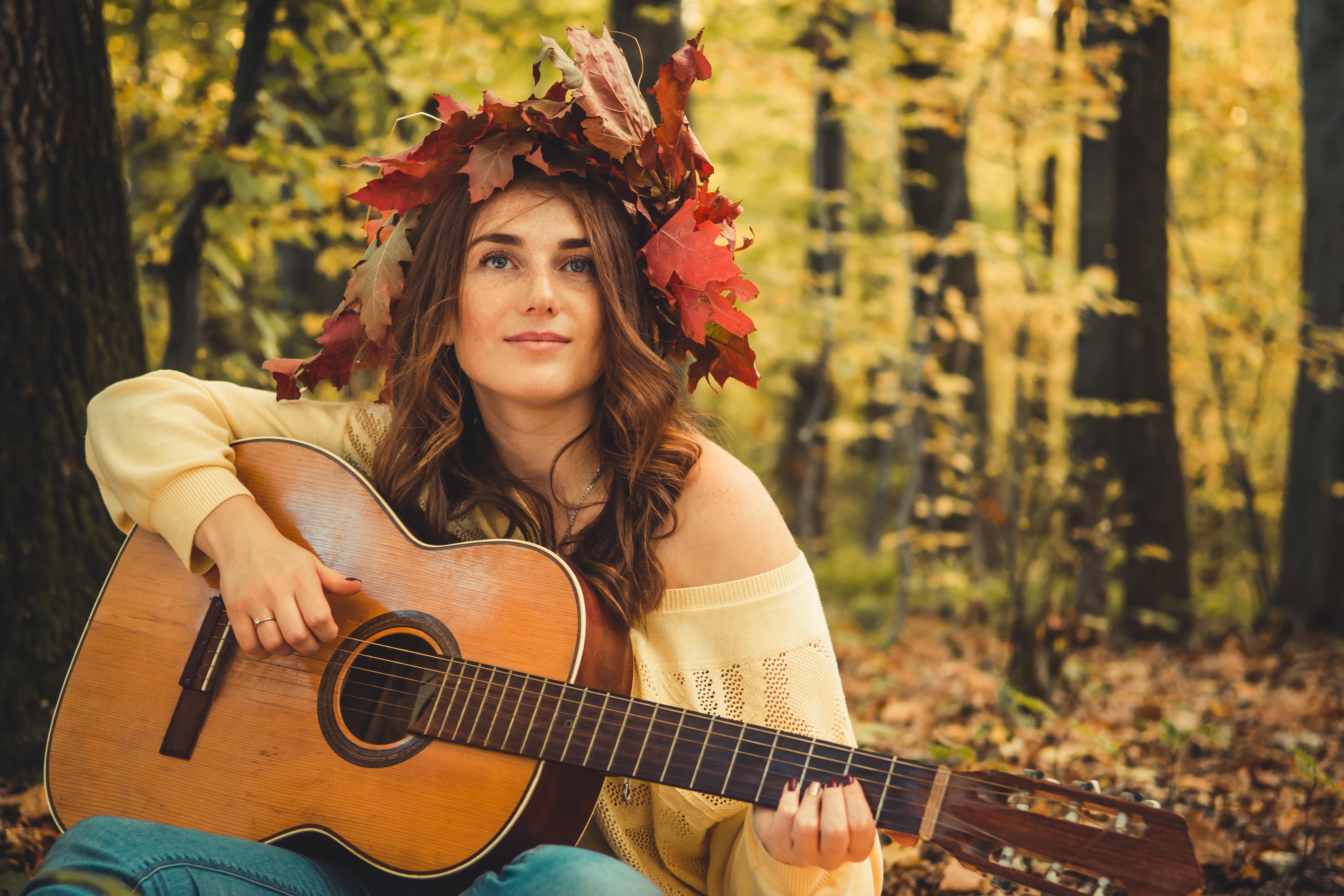 Rapariga na floresta com guitarra na mão