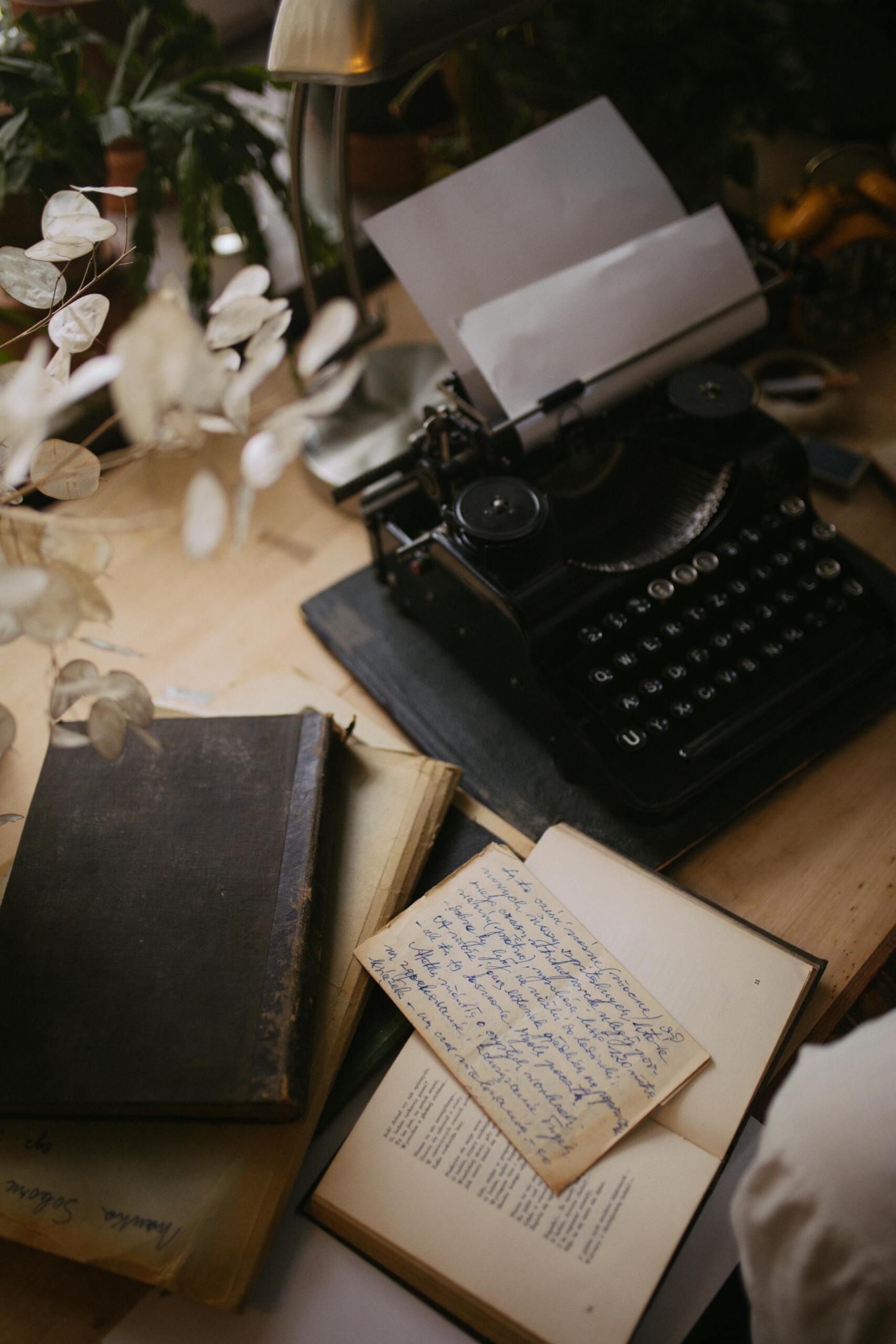 livros, folhas e máquina de escrever