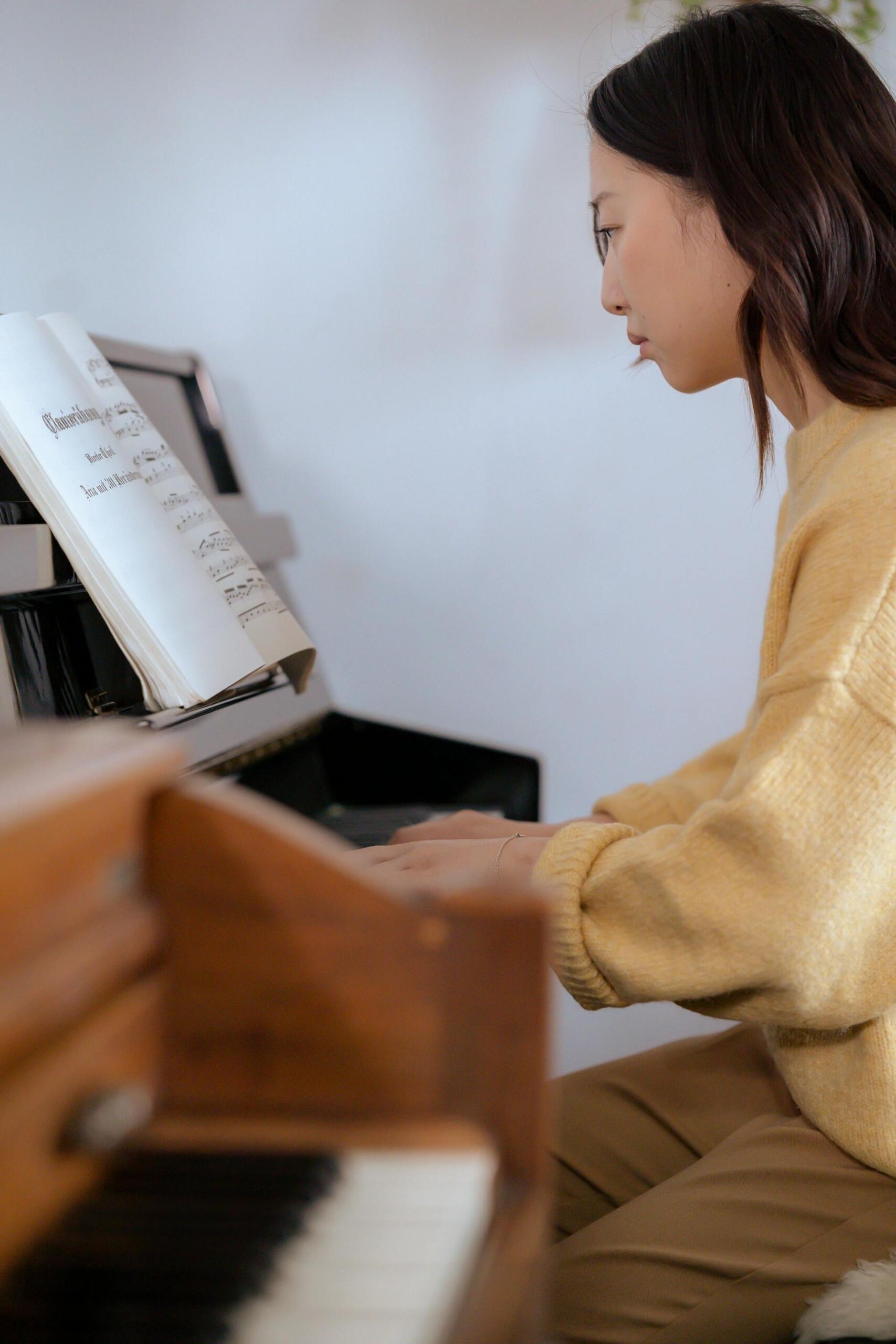 mulher de camisola amarela a tocar piano