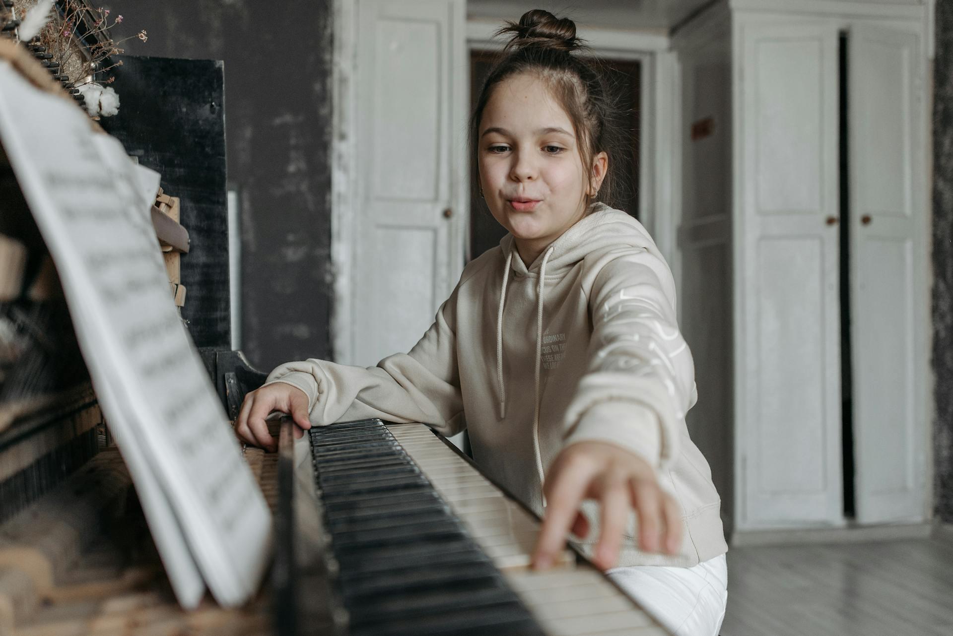 menina a brincar com teclas de piano