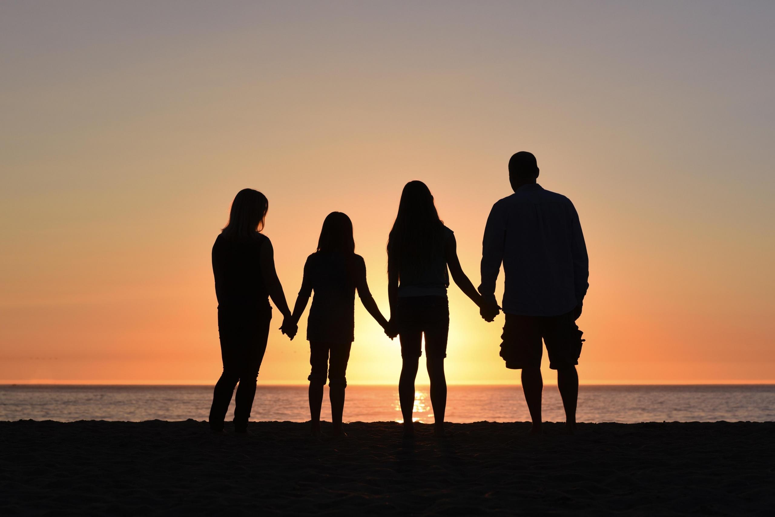 Pessoas de mãos dadas a ver o pôr-do-sol