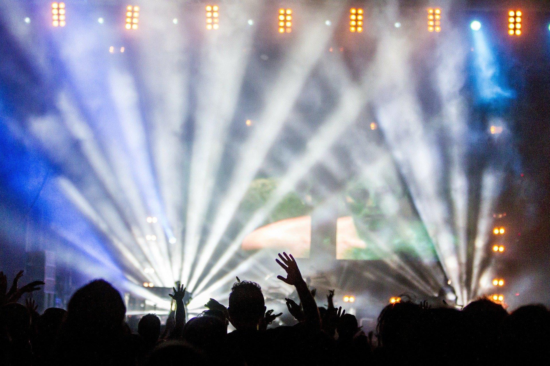 Um fotografia de um concerto, luzes e multidão.