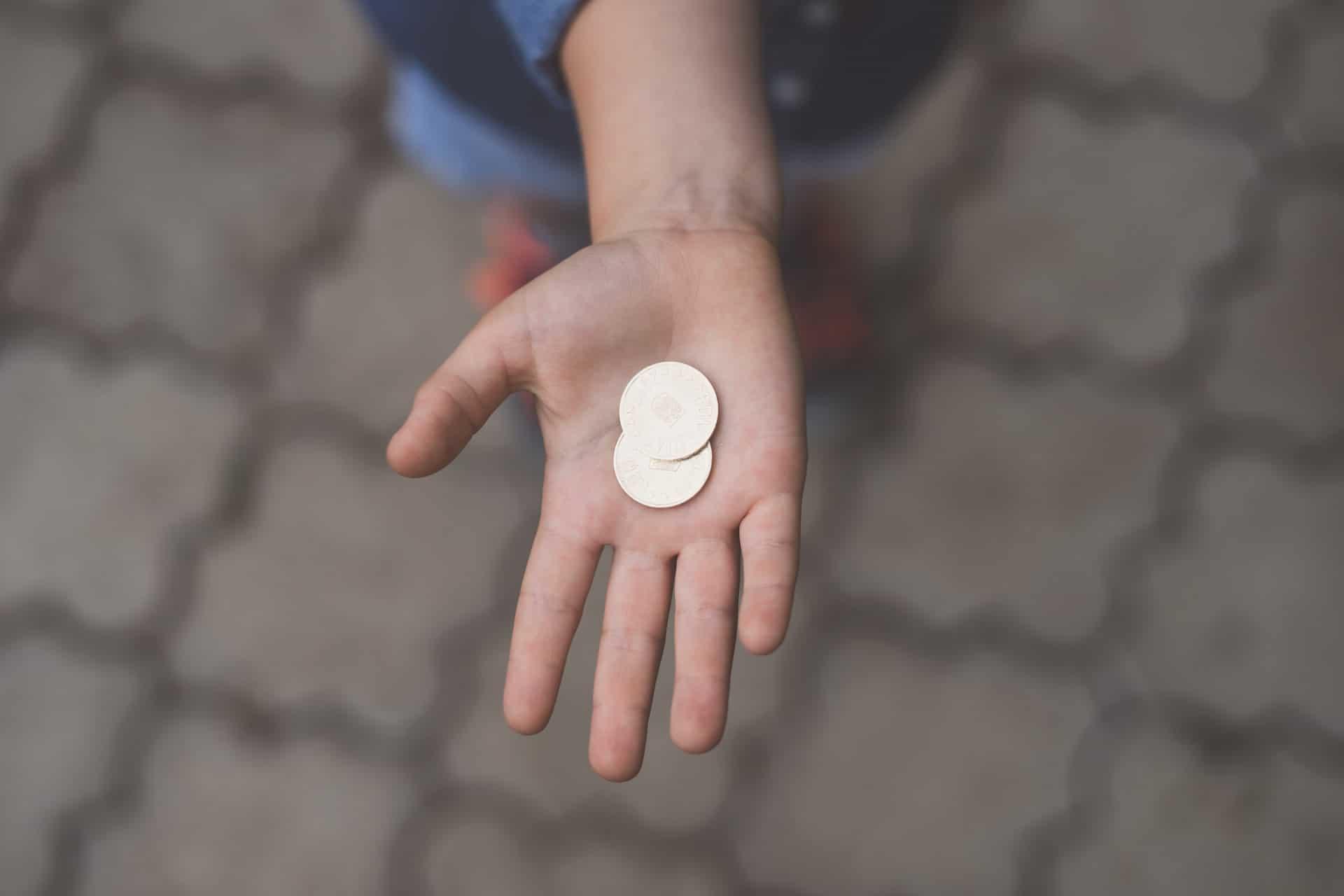 Mão estendida com moedas