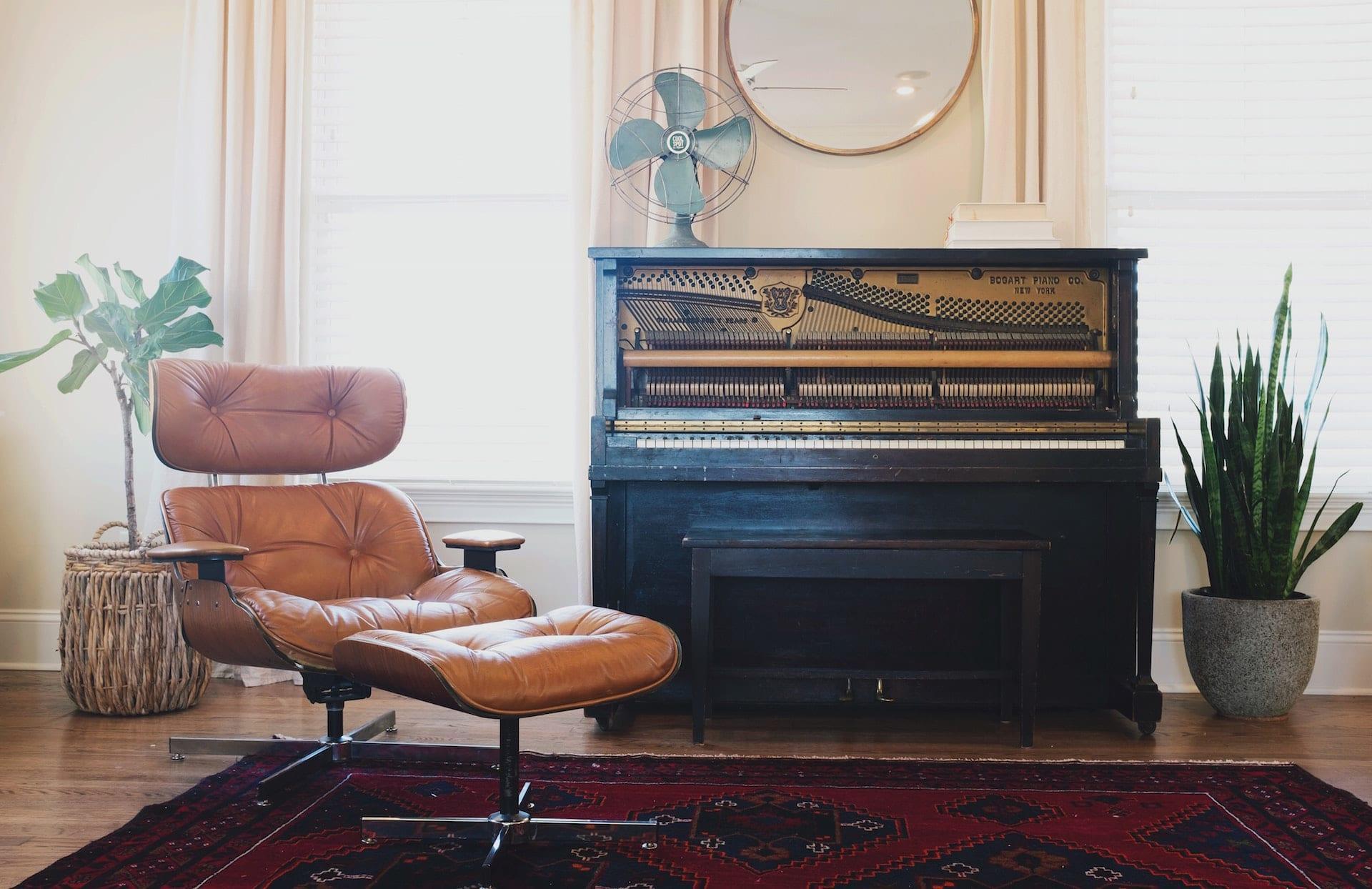 Sala de estar com cadeirão e piano vertical