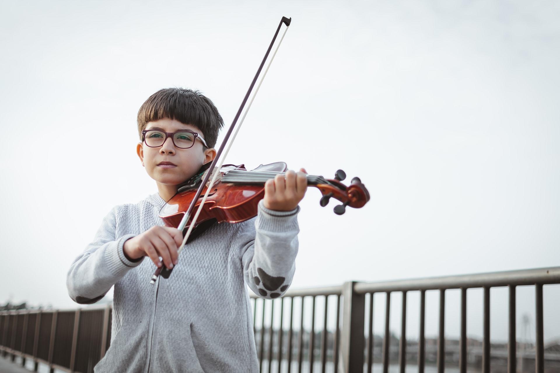 crianca a tocar violino numa ponte