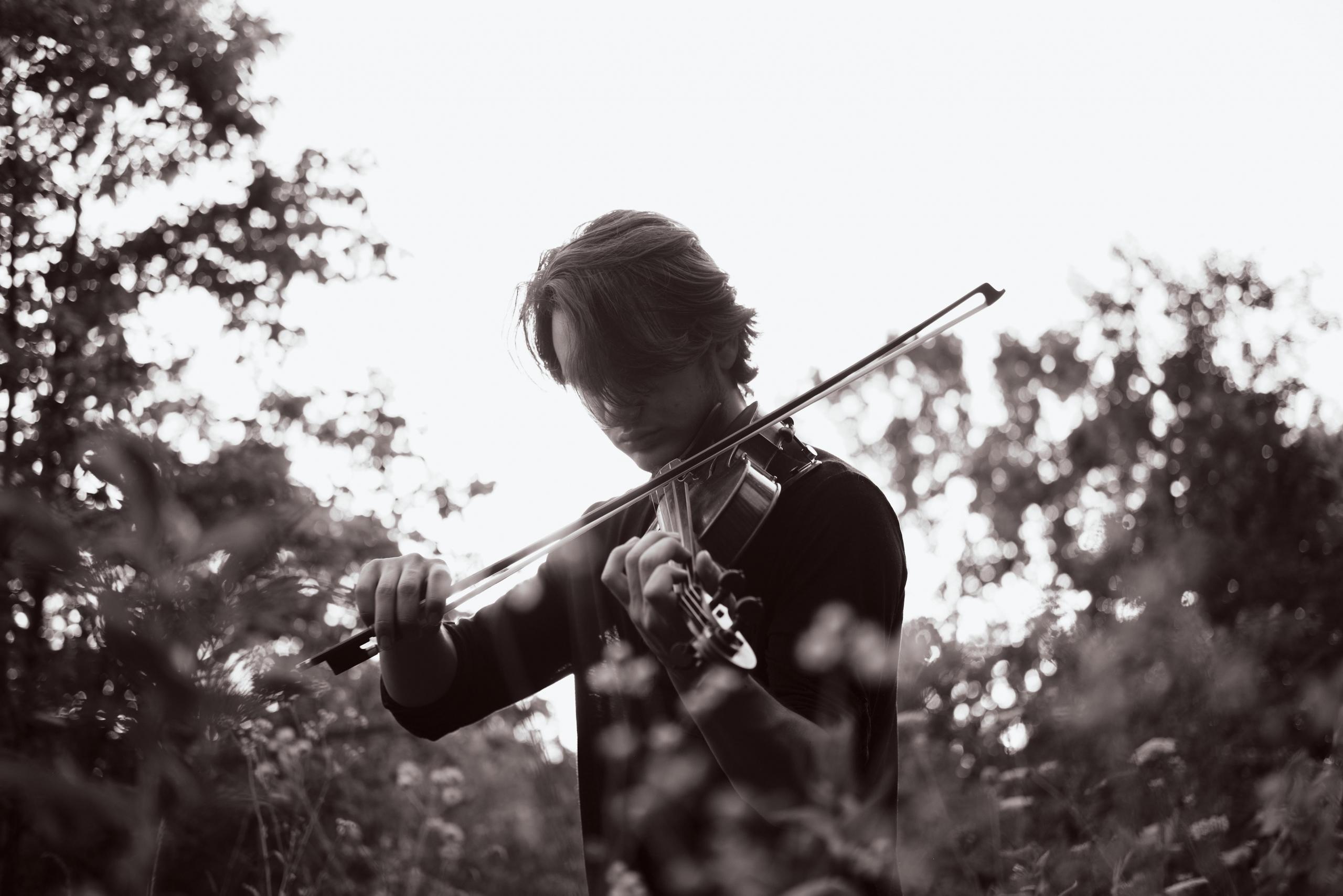 homem com violino e mato