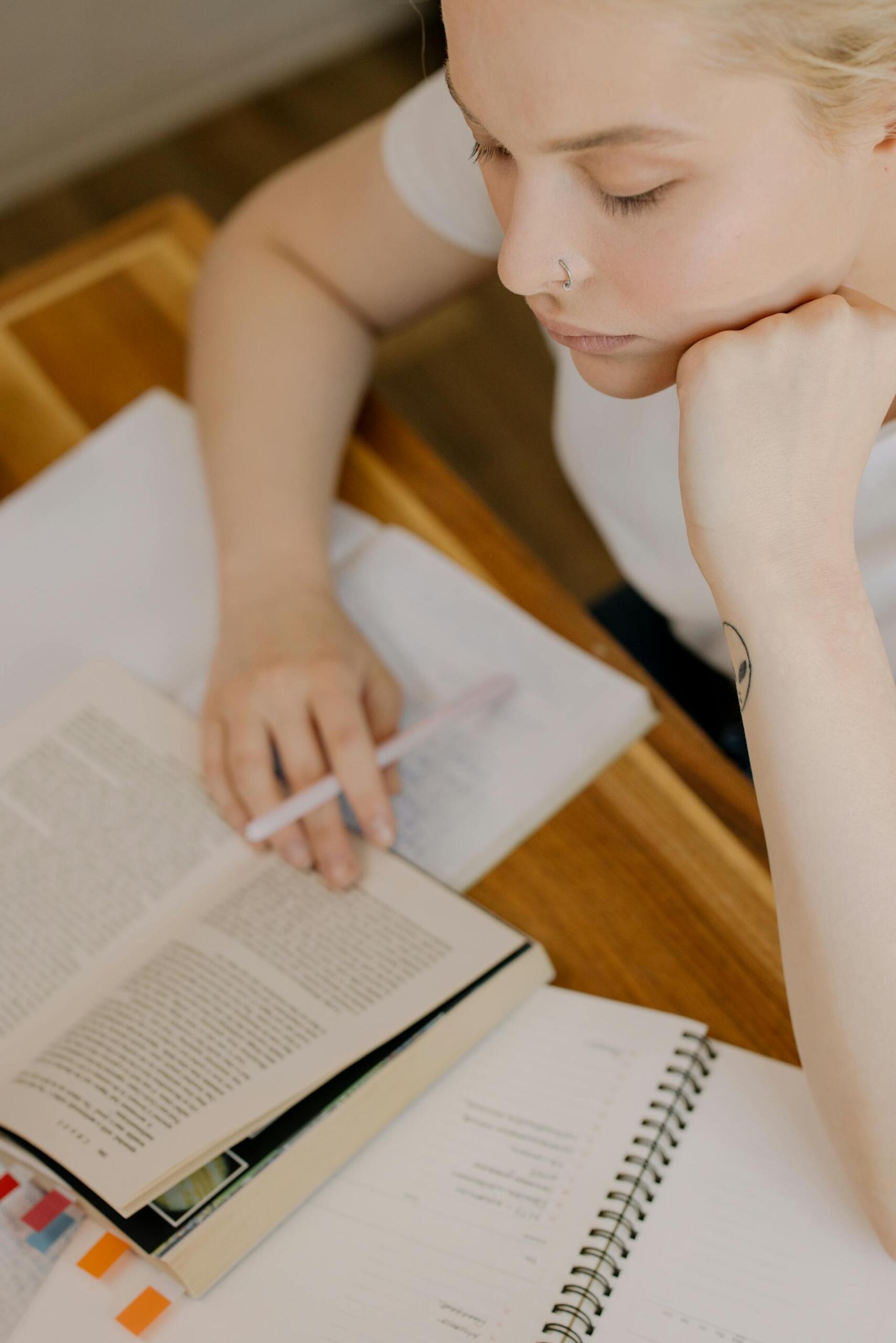 rapariga a tirar apontamentos com livro aberto
