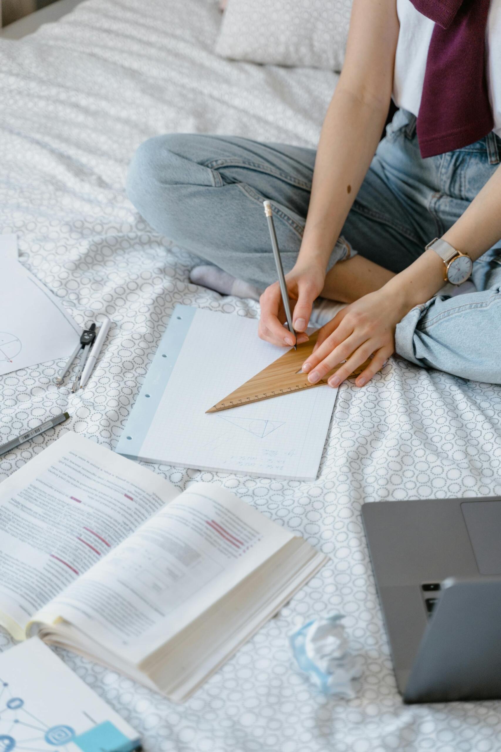 pessoa a fazer linha com esquadro num caderno