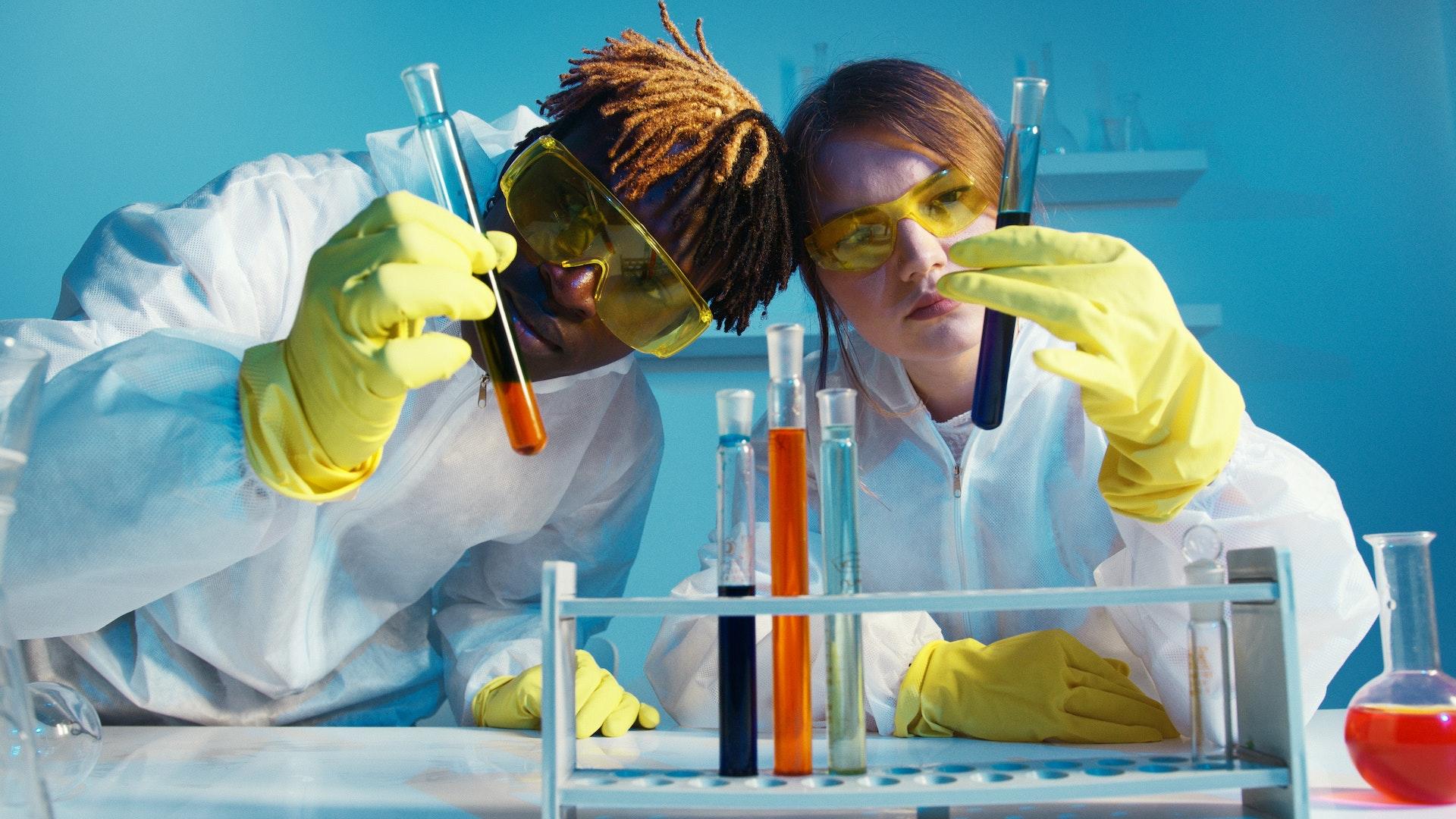 dois alunos com tubos em laboratorio