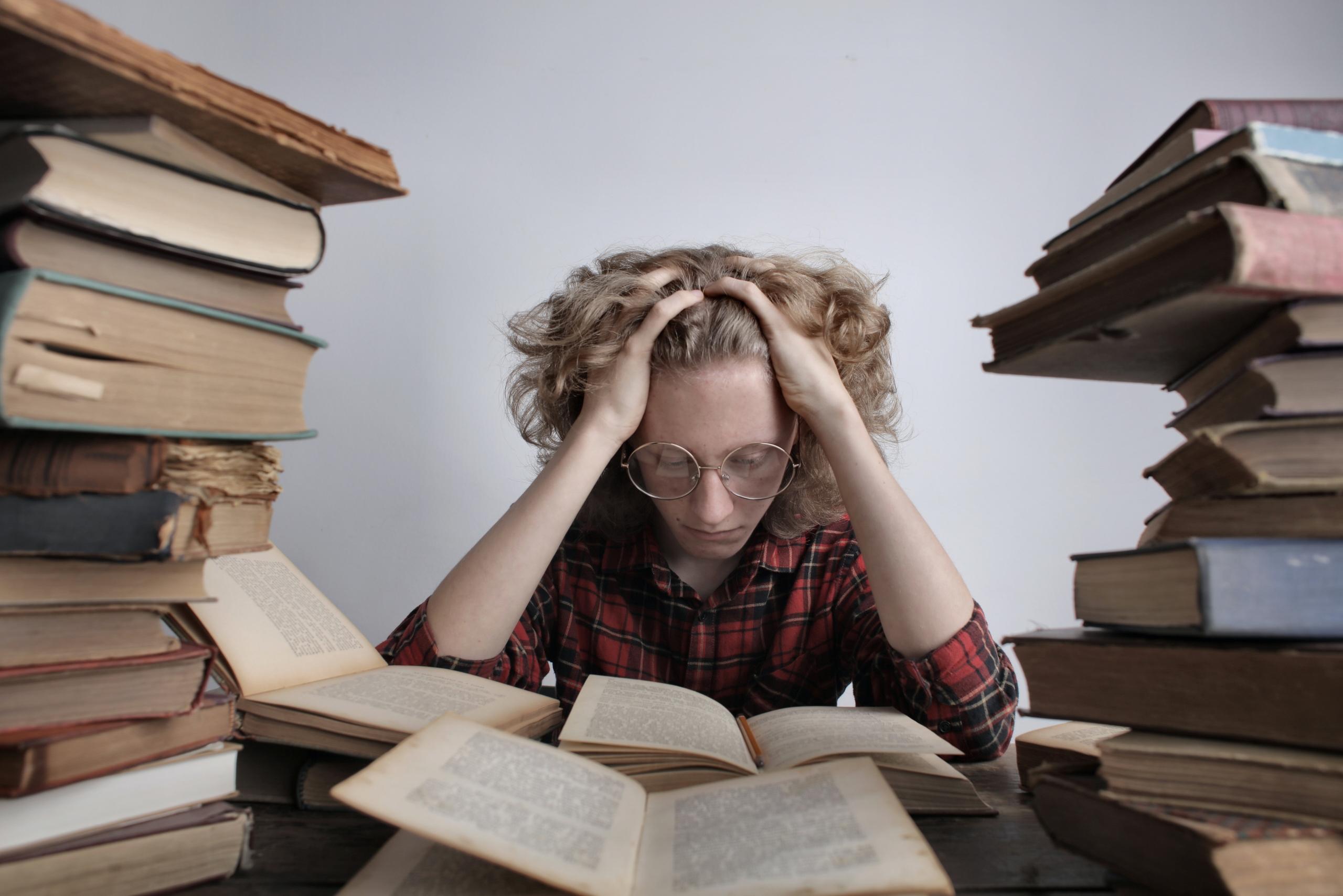 aluno com pilhas de livros