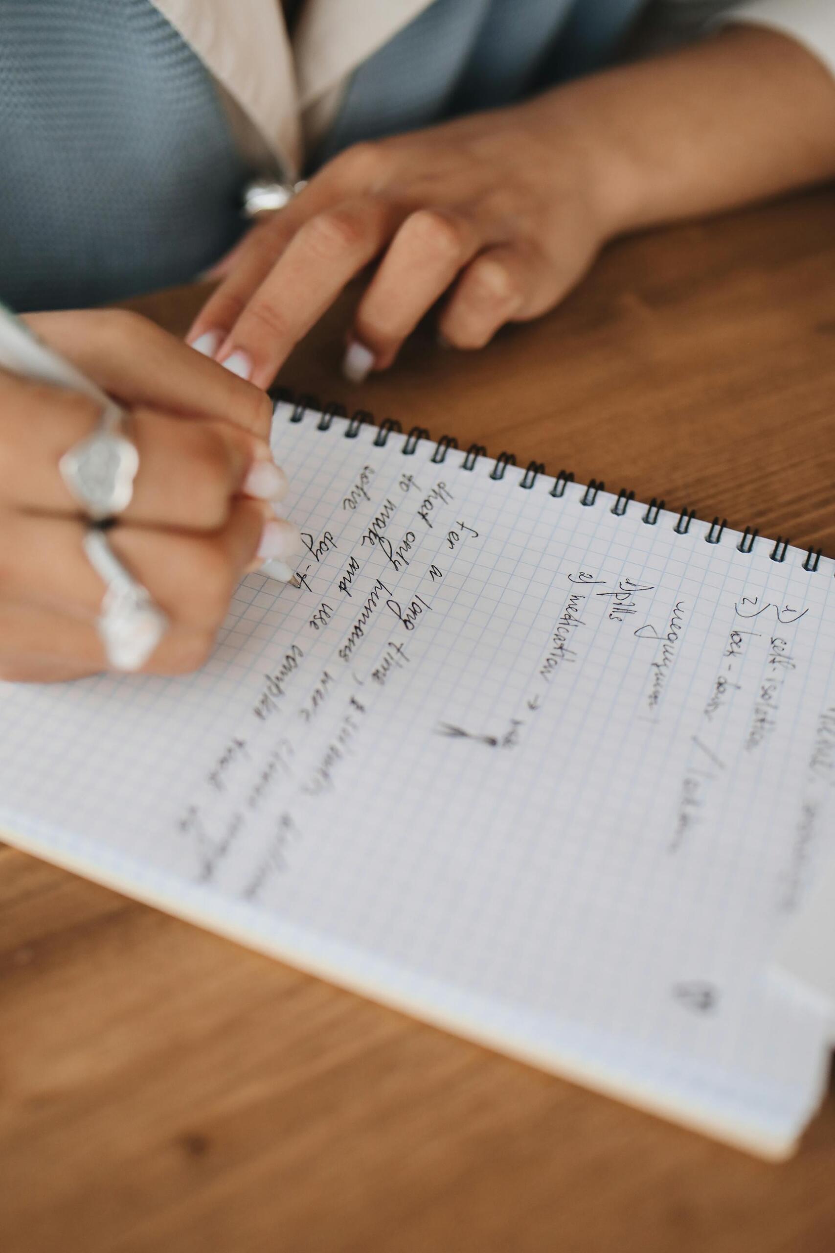 mãos de mulher a escrever num caderno