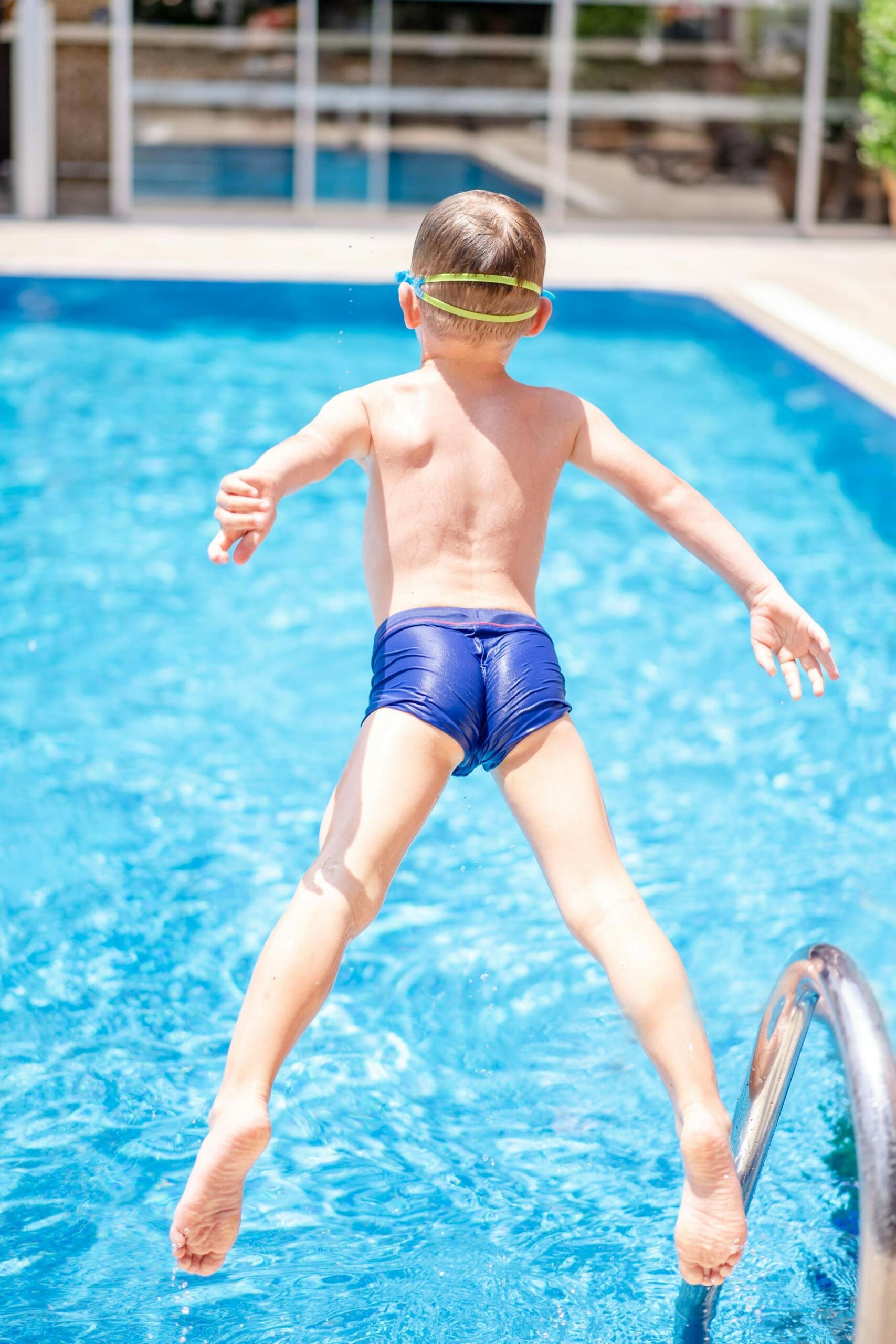menino a atirar-se para dentro da piscina