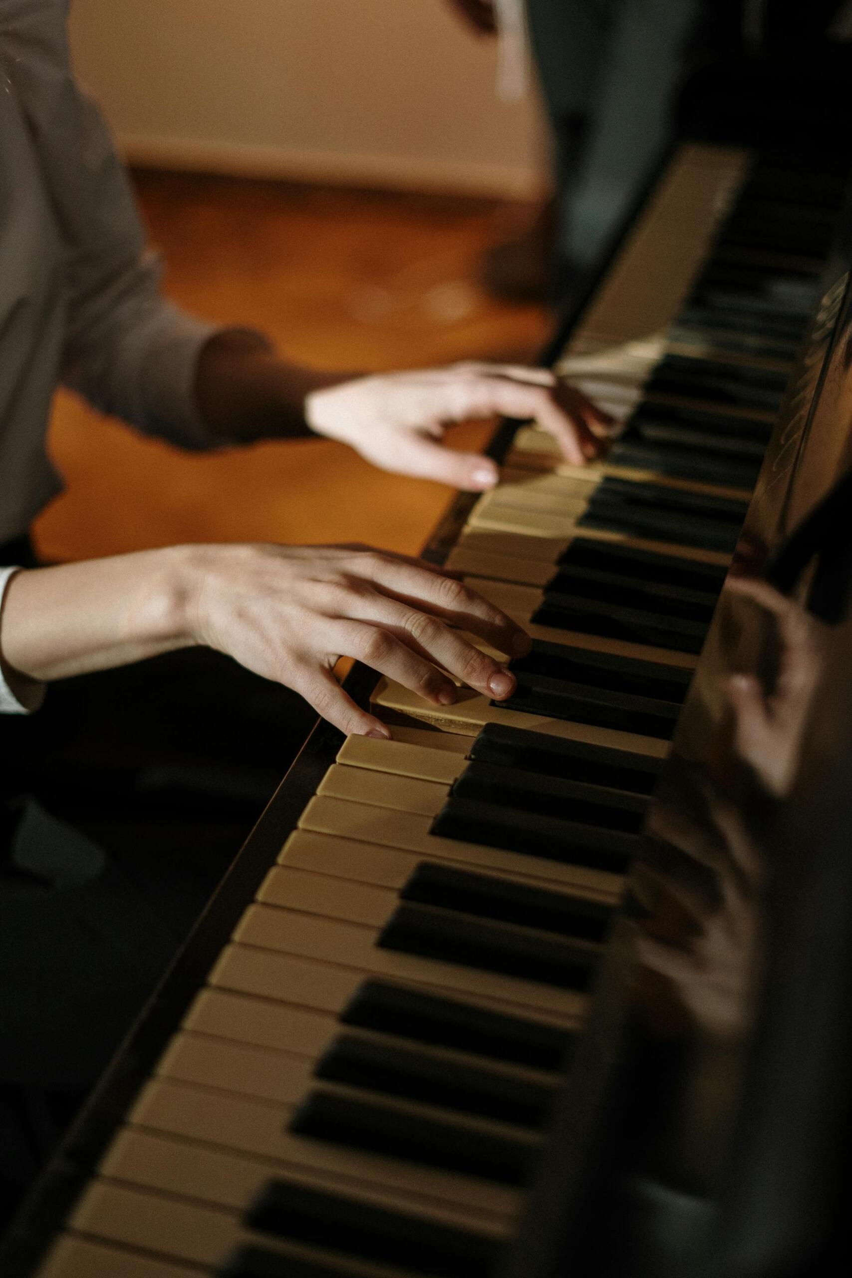 mãos de pessoa a tocar piano