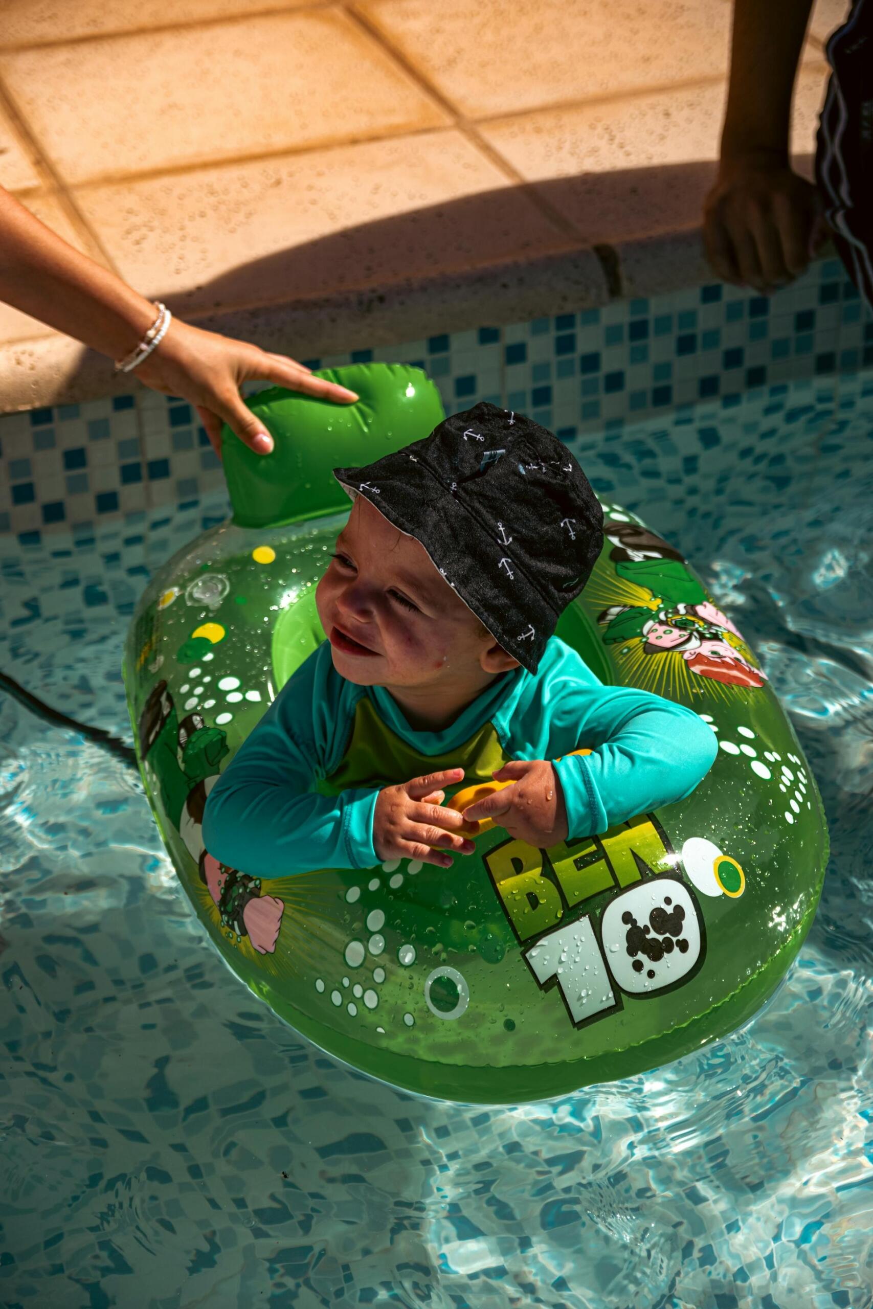 bebé com chapéu dentro de boia